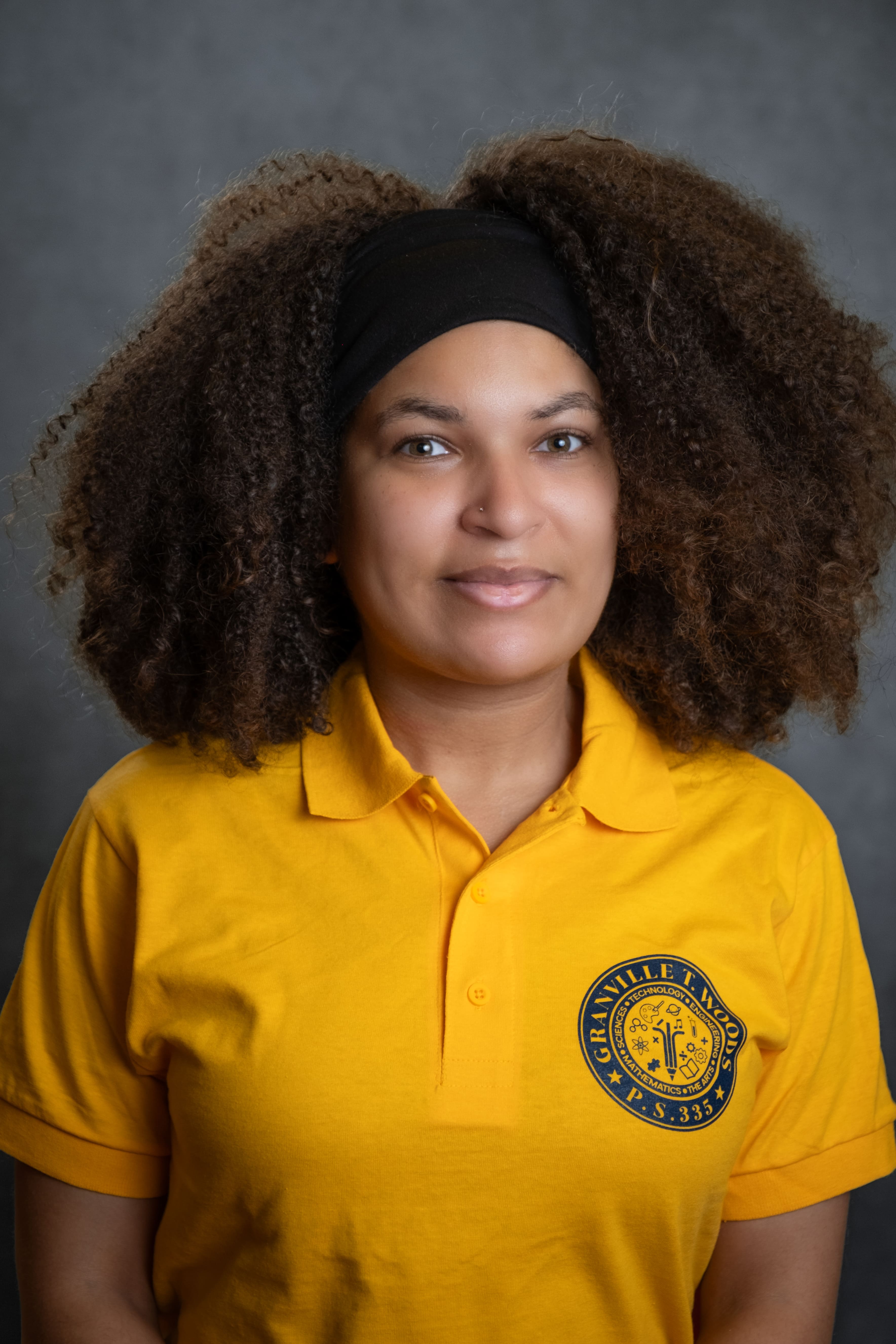 L. Gomez staff member wearing Granville T. Woods P.S. 335 polo shirt