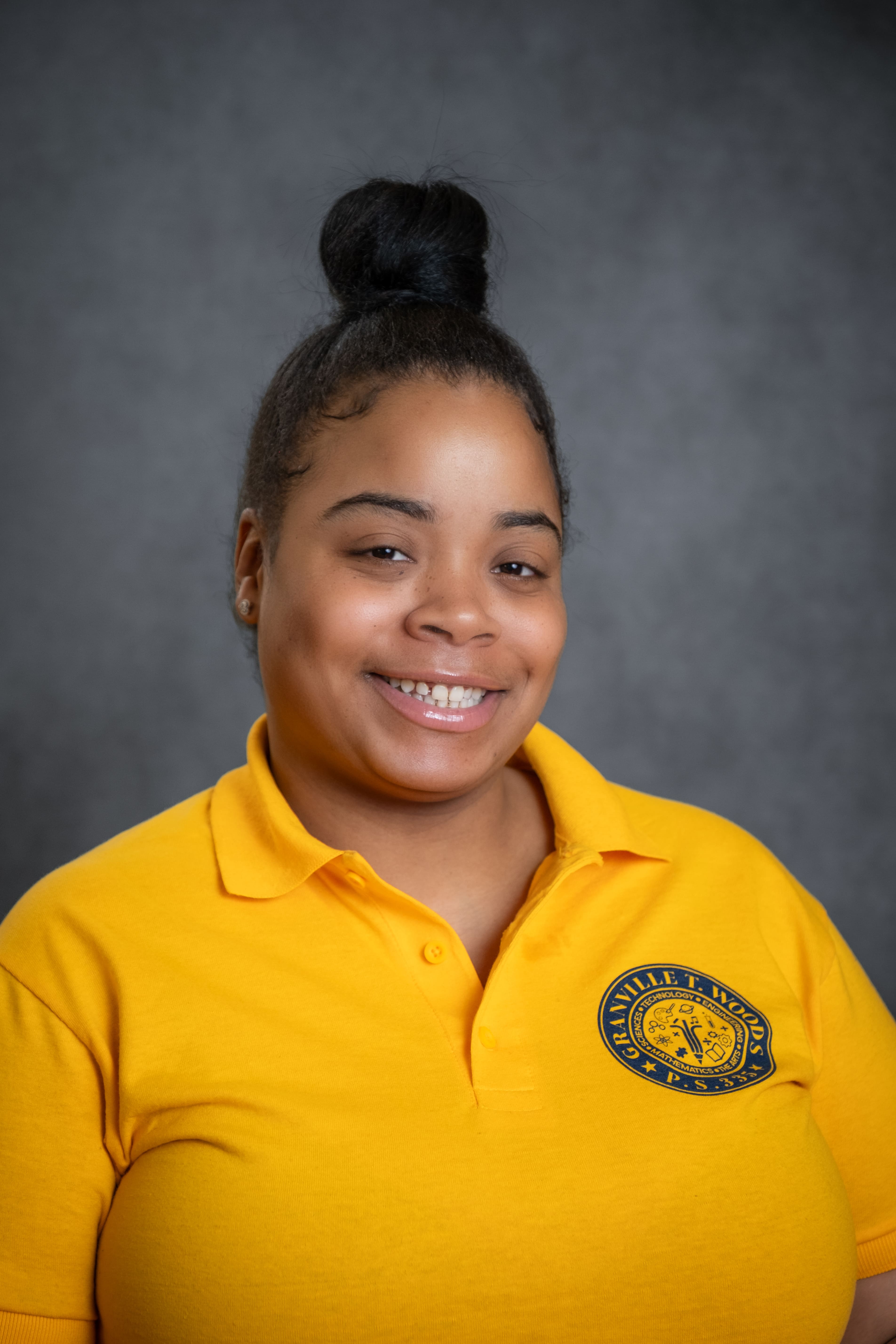 Smiling Granville T. Woods PS 335 staff member in school polo