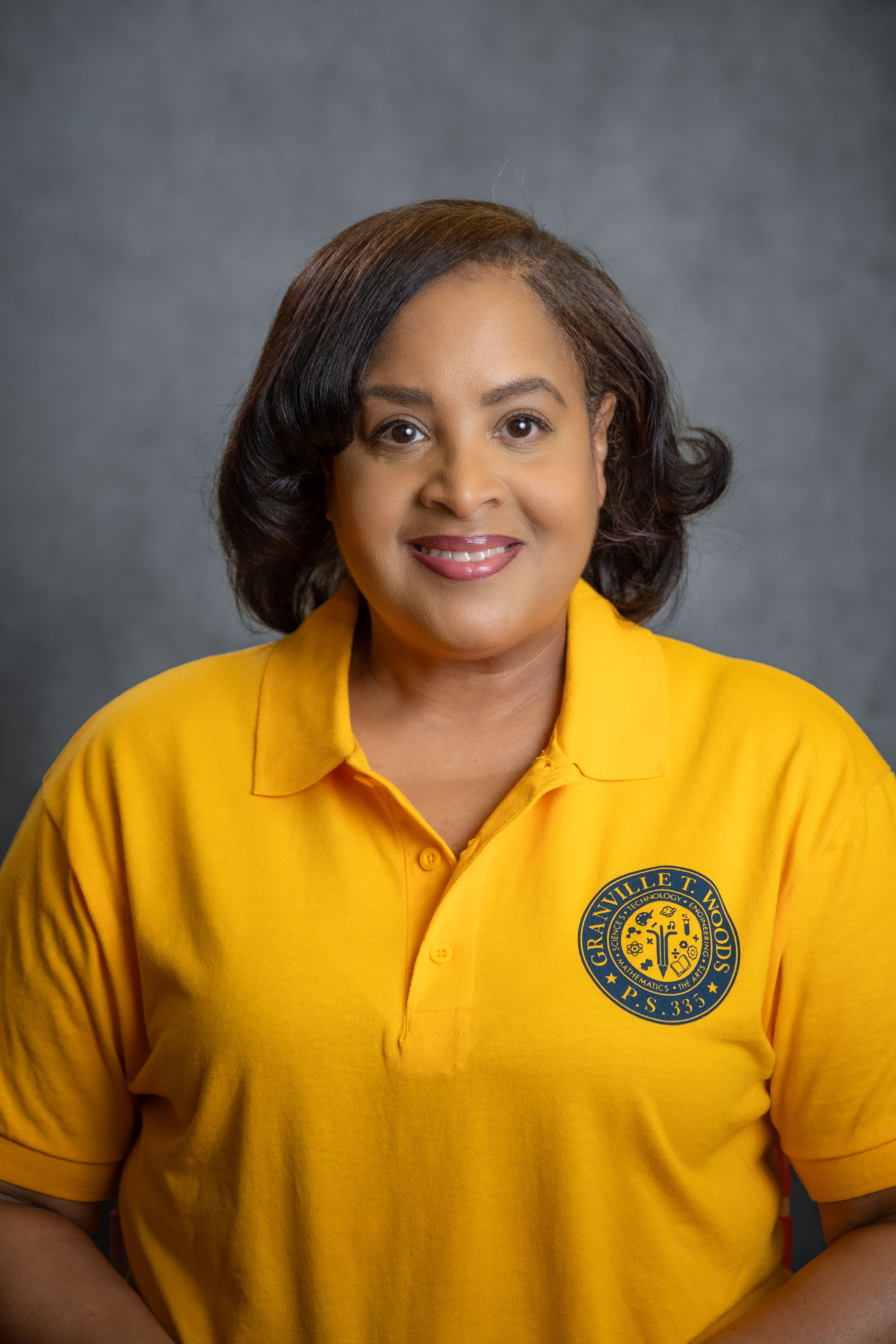 Staff member M. Jackson wearing a Granville T. Woods PS 335 polo shirt