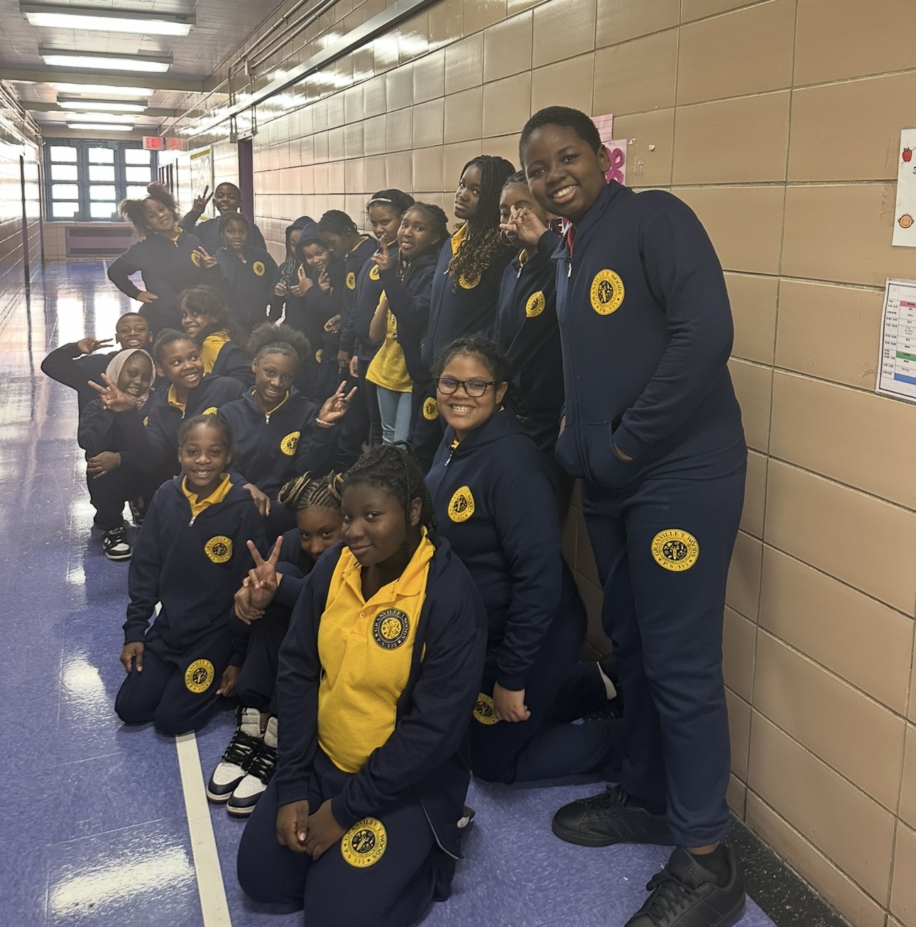 Students in school uniforms posing together in a hallway