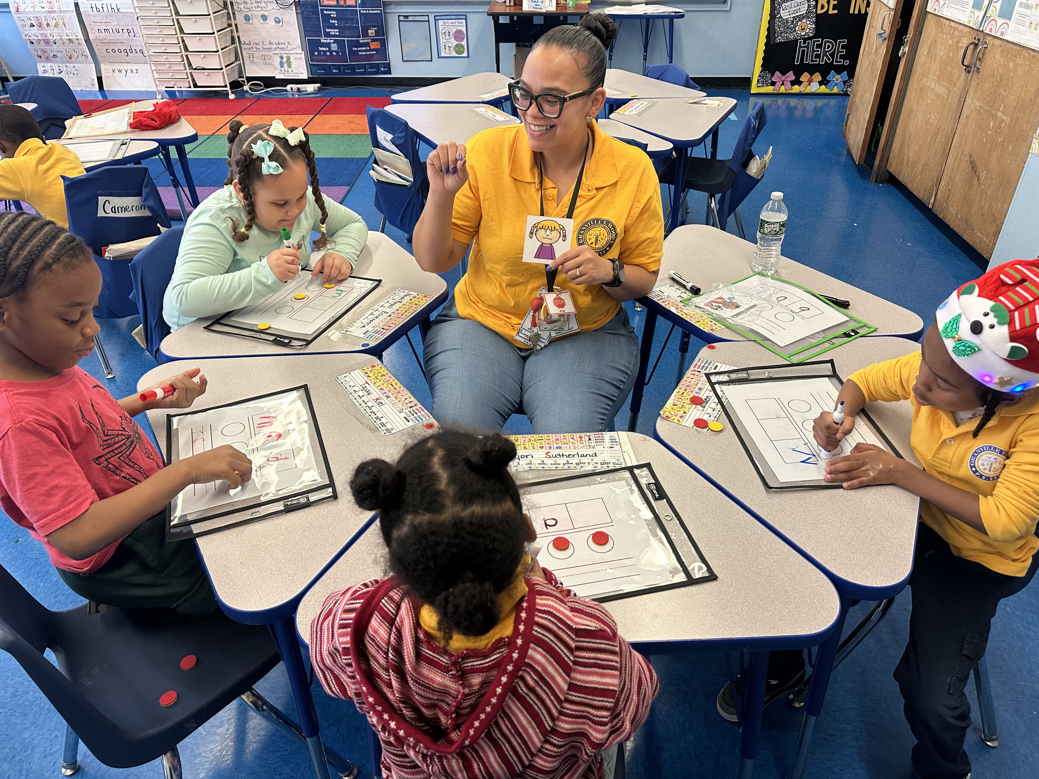 Teacher leading small group reading lesson with elementary students