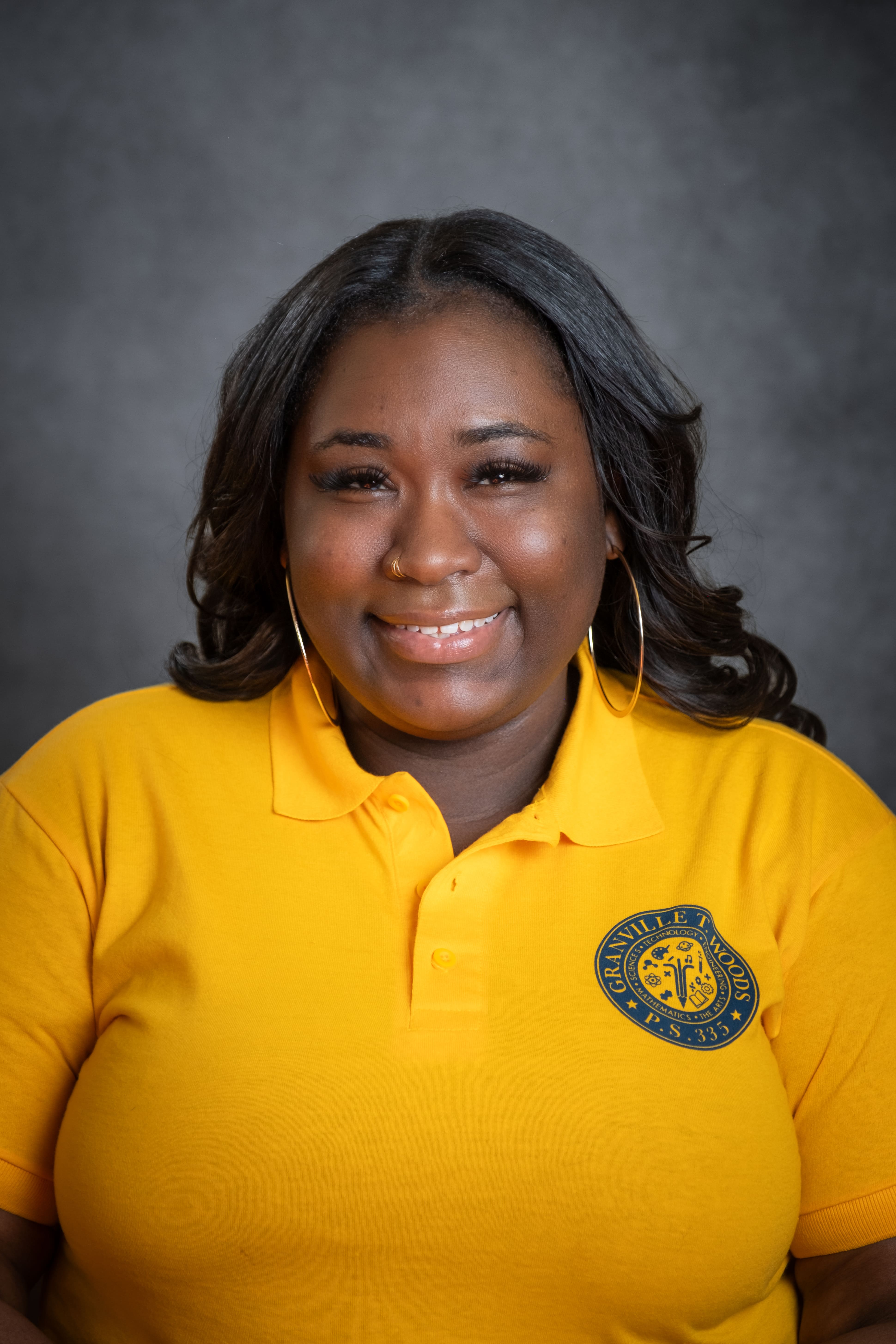 Staff member N. Stewart smiling in Granville T. Woods PS 335 polo shirt