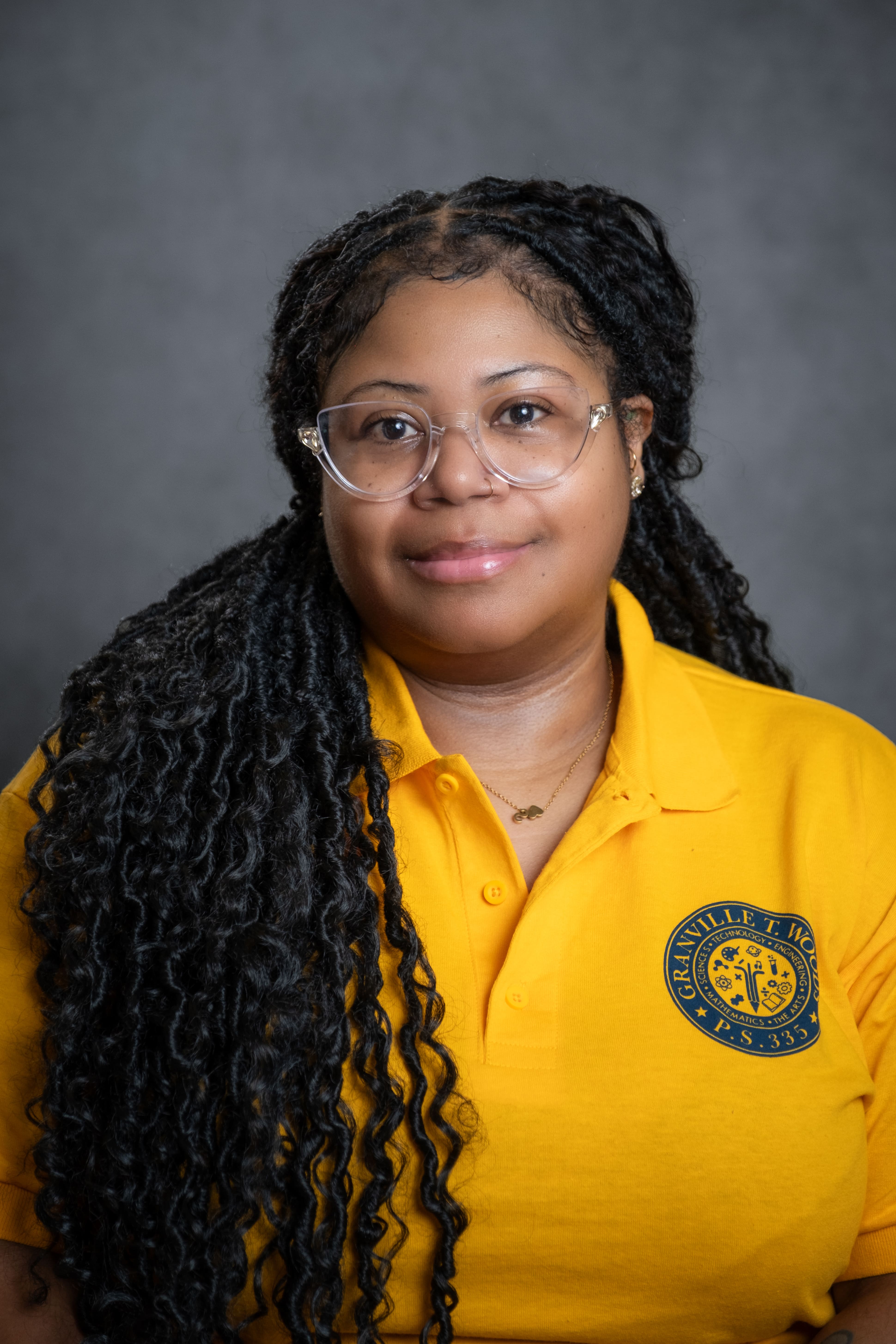 Staff member S. Rivera wearing a Granville T. Woods P.S. 335 polo shirt