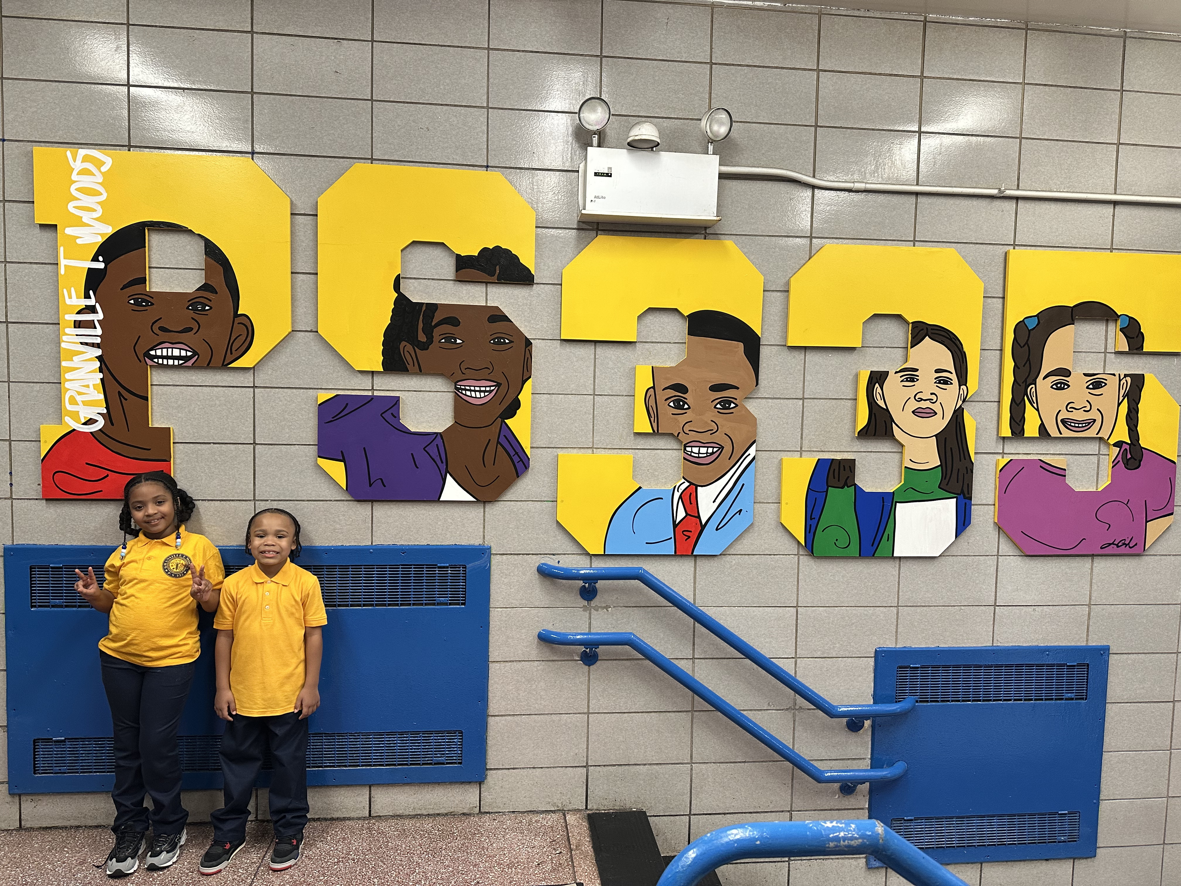 Two students posing in front of PS 335 Granville T Woods school mural
