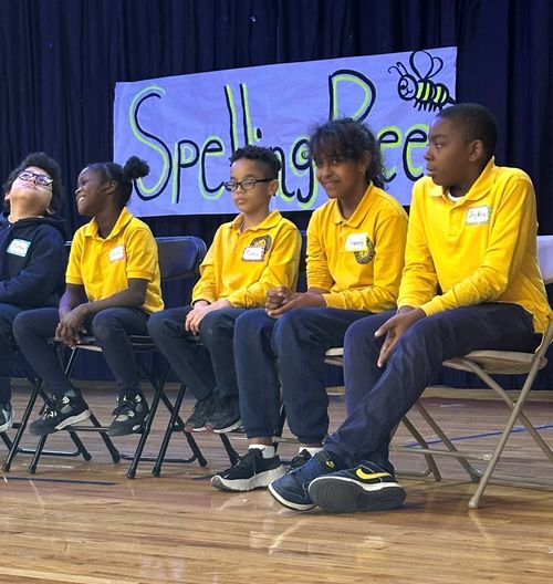 Students seated on stage during school spelling bee competition
