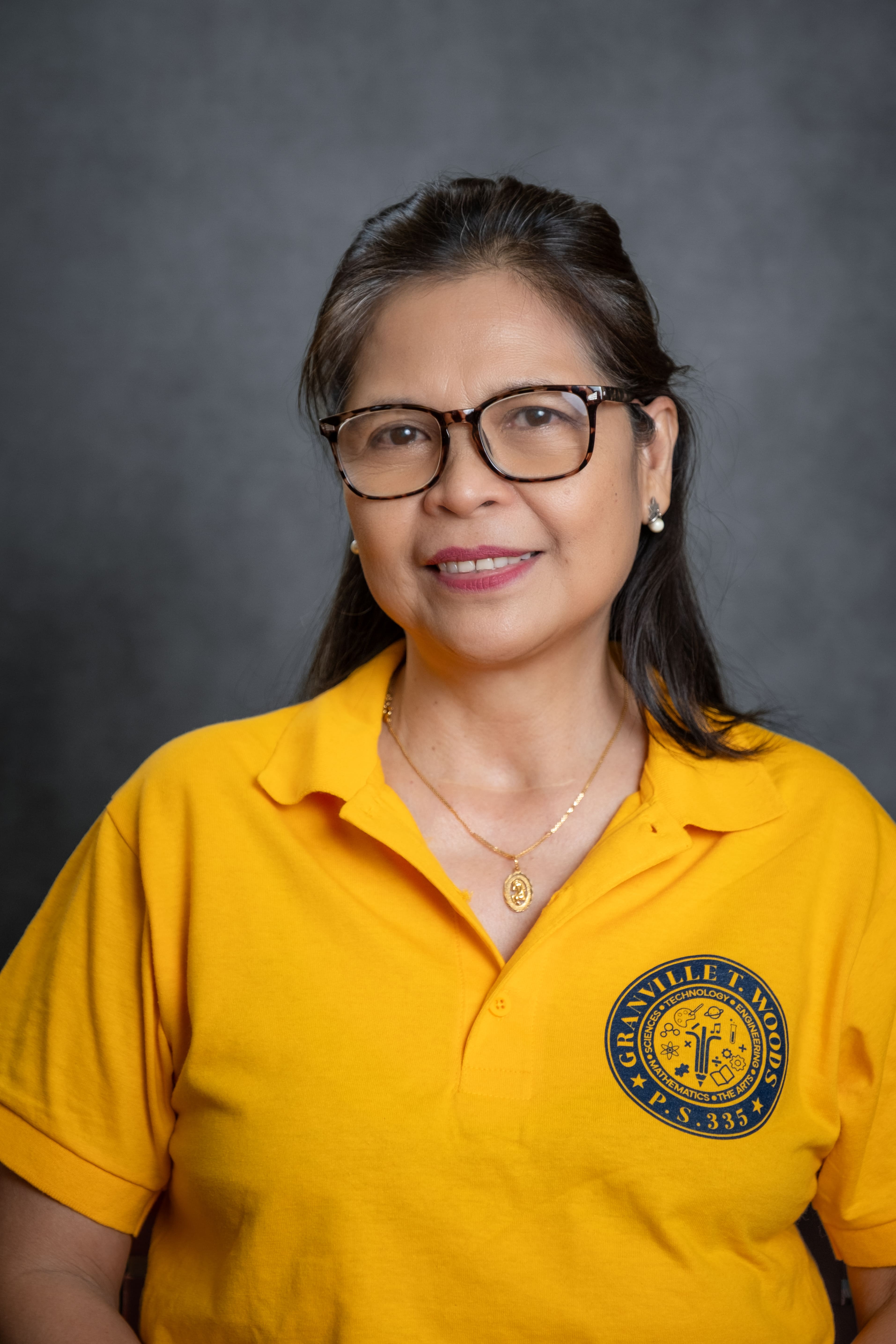 Staff member F. Montarde wearing a P.S. 335 school shirt