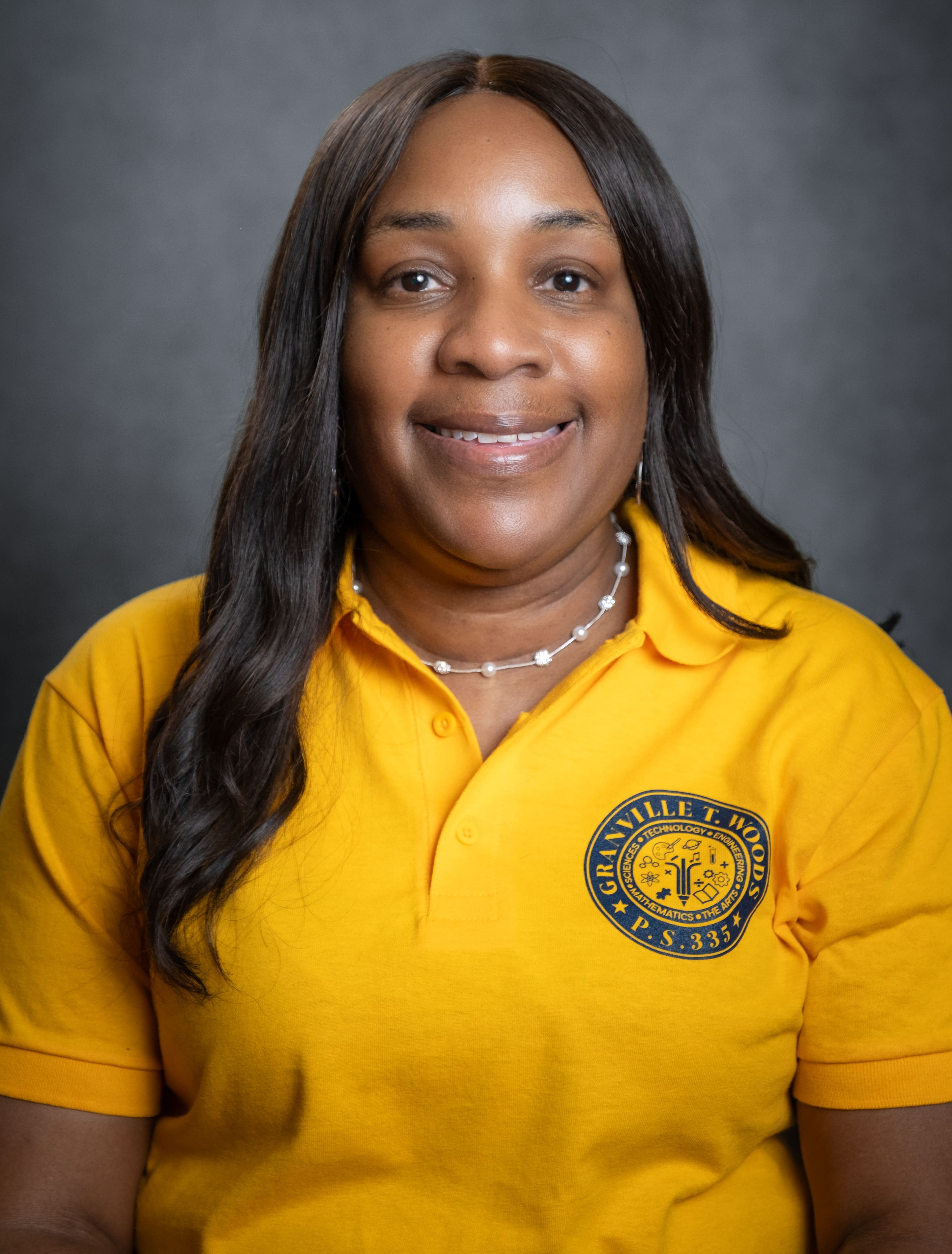 PS 335 principal smiling in school polo shirt
