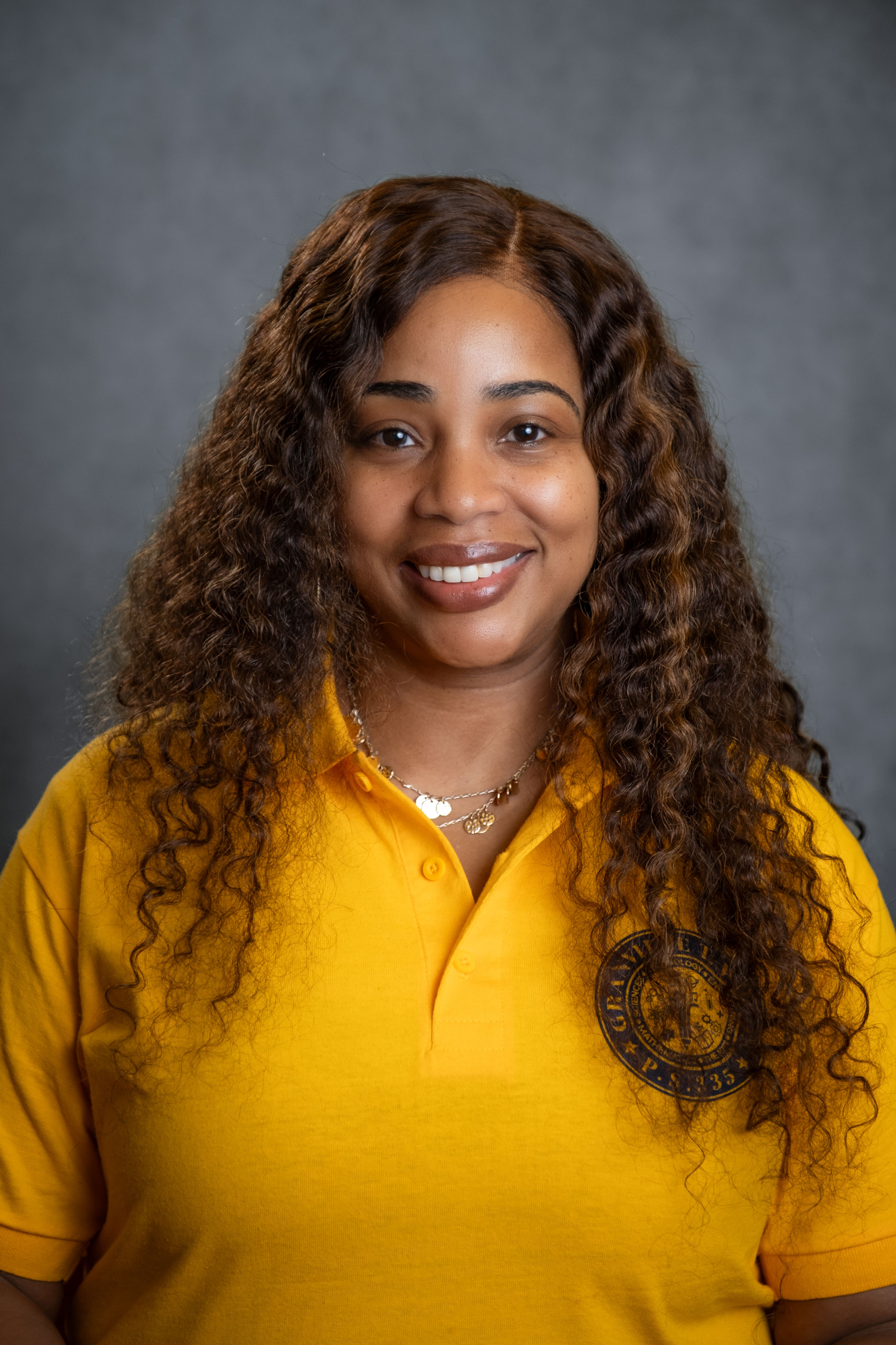Staff member M. Miller smiling in PS 335 school uniform