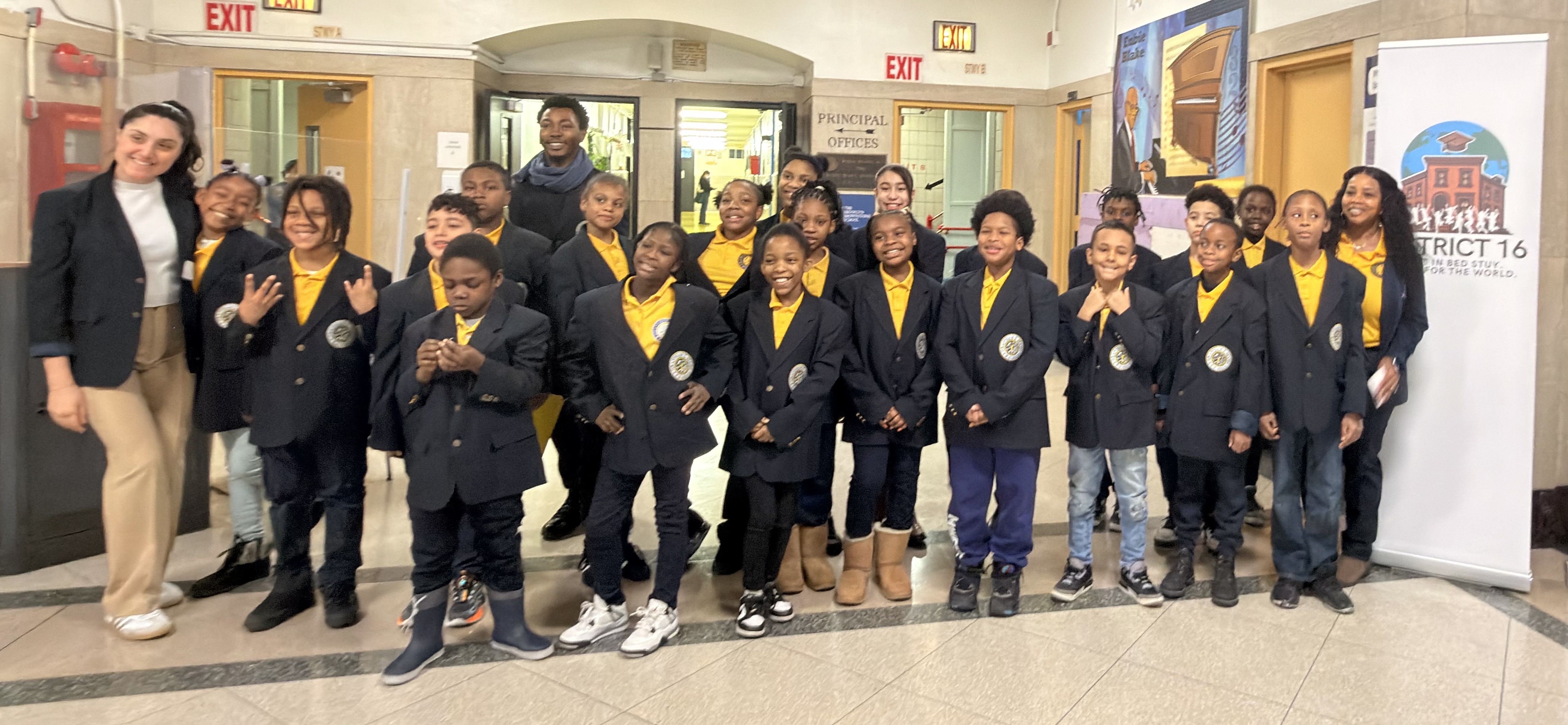 Students in uniform blazers posing with adults at District 16 event