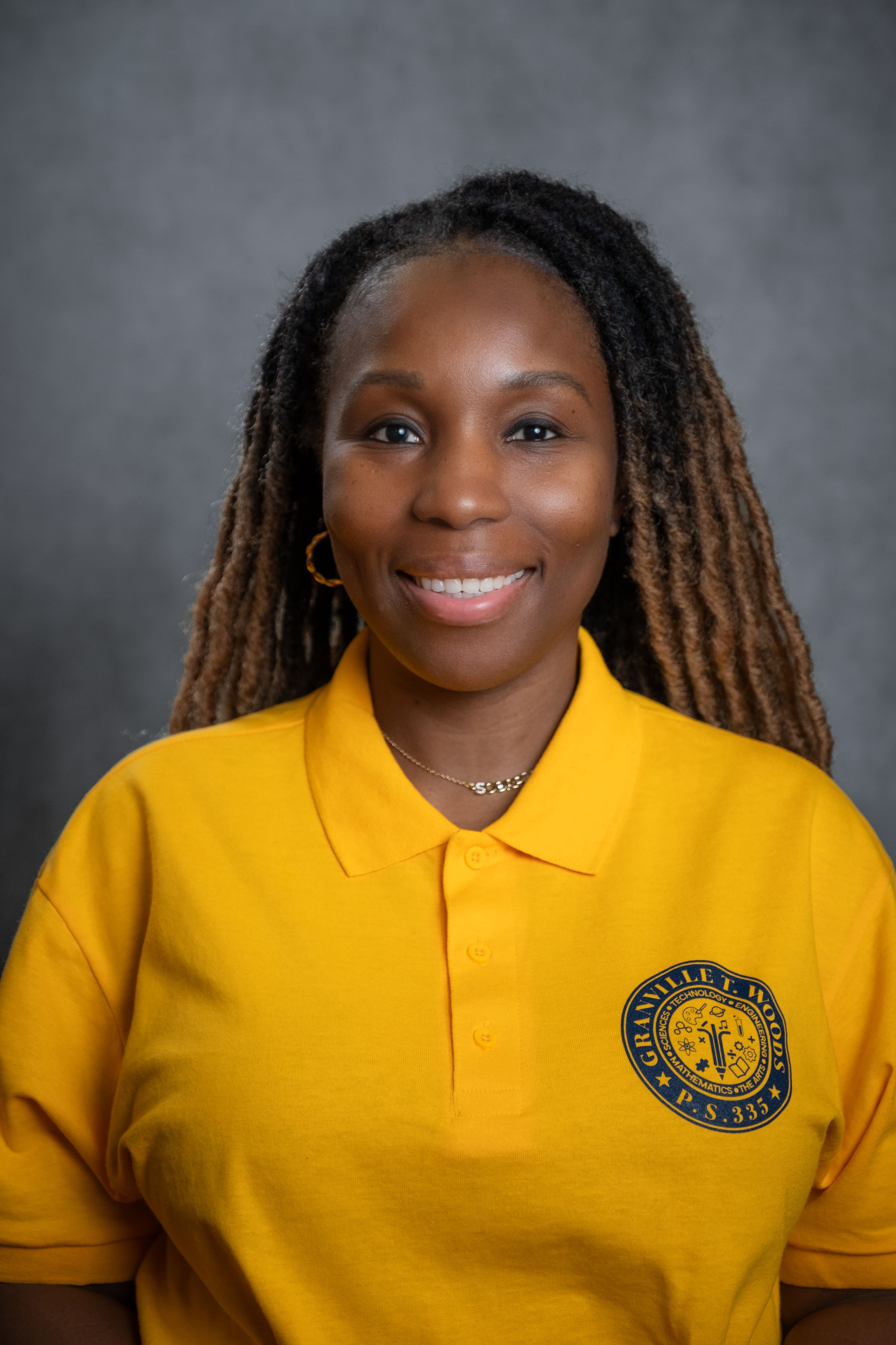 Staff member T. Rose smiling in Granville T. Woods PS 335 polo shirt