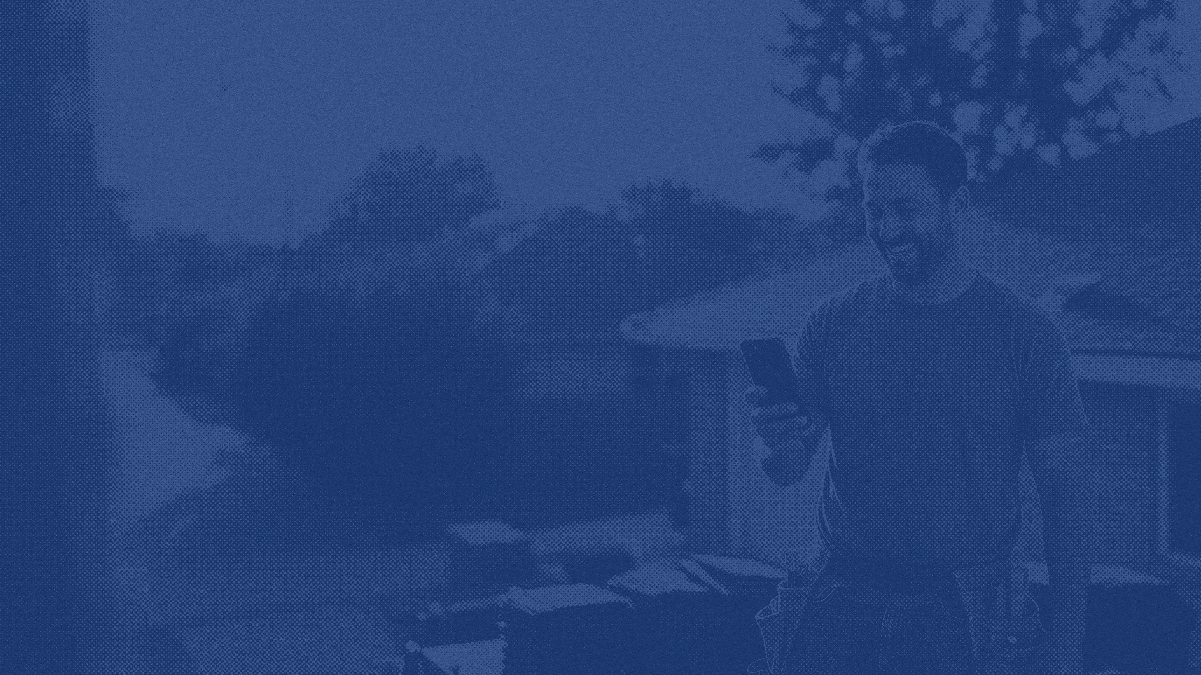 Worker installing or repairing roof shingles, shown in a blue duotone filter.