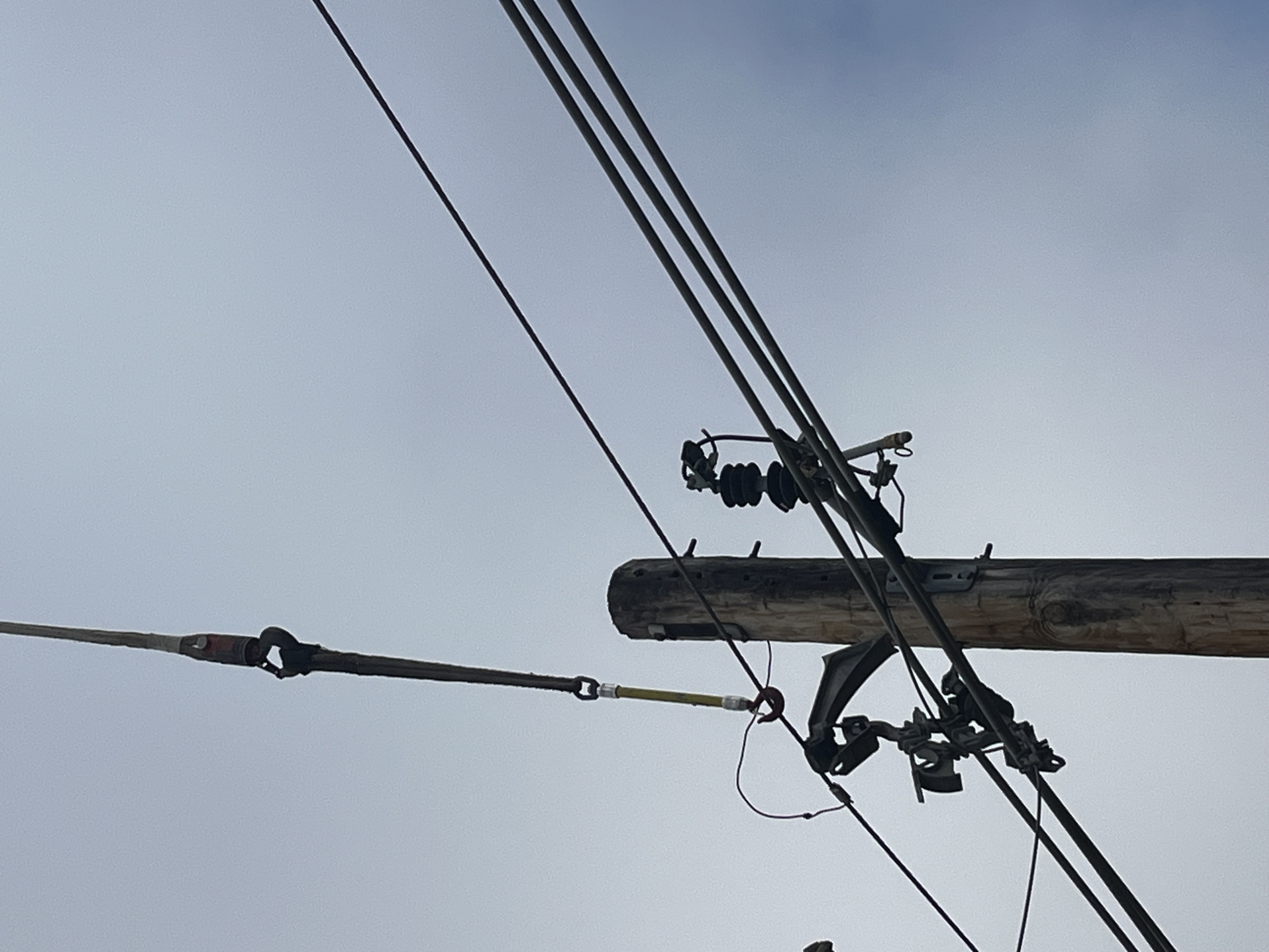 A temporary cable holds up a power wire next to a broken Hendrix bracket.