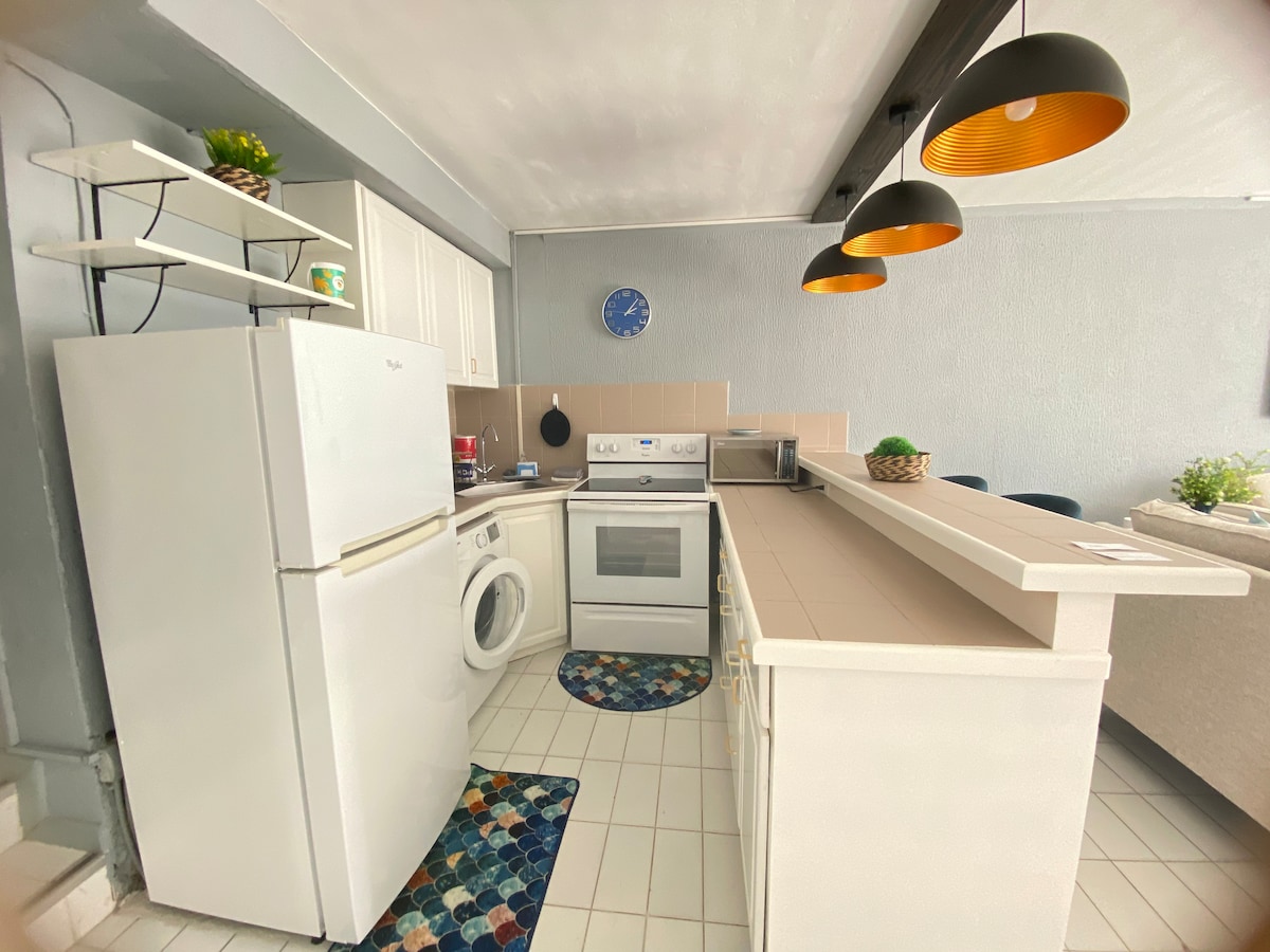 Full kitchen with refrigerator, stove and washer