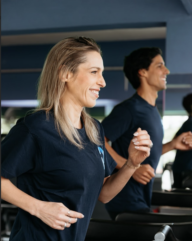 Dos personas corriendo en un gimnasio