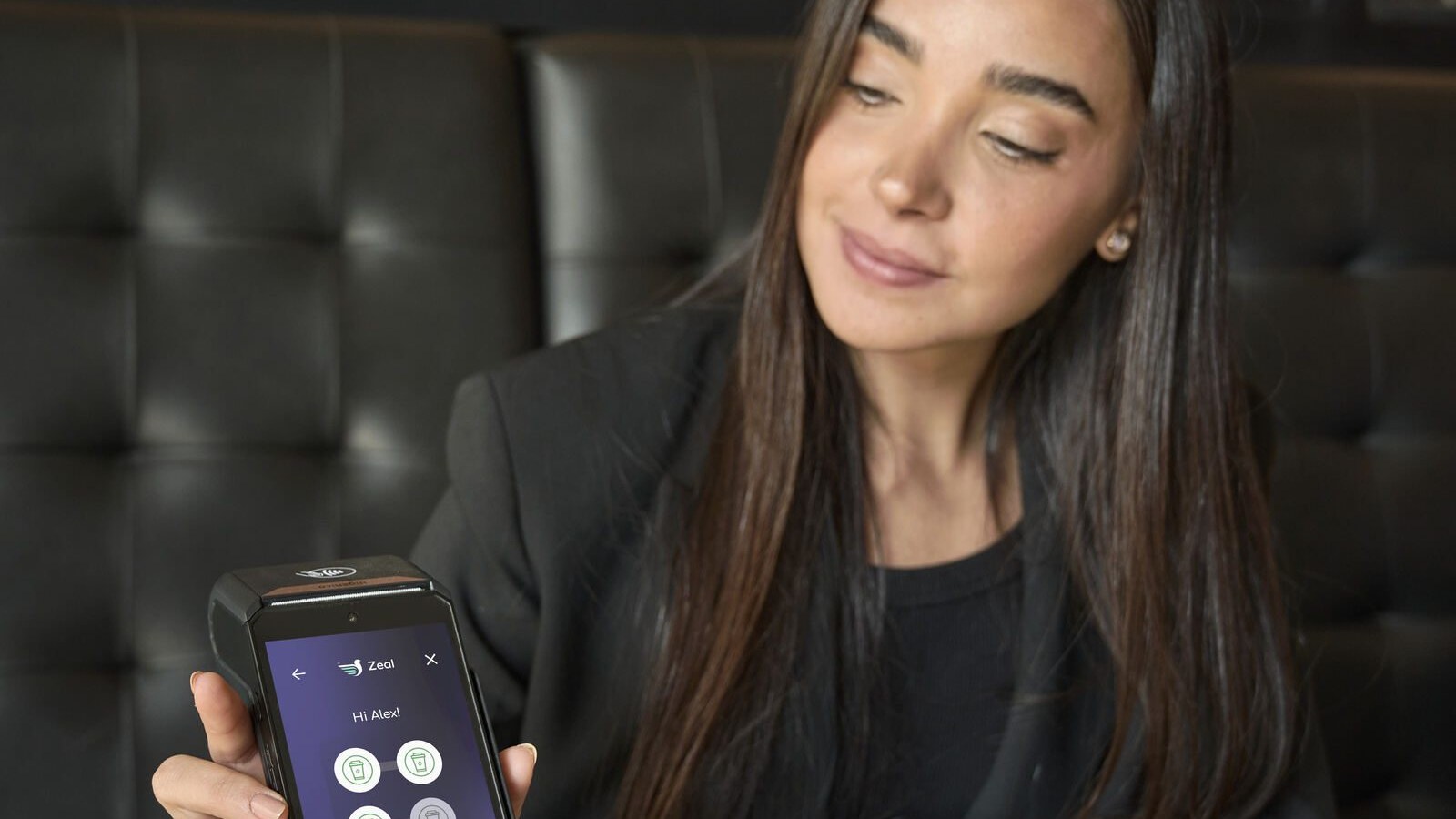 Customer holding a phone beside a Zeal-enabled card machine