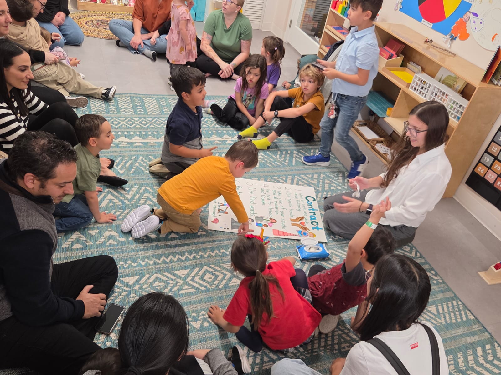A teacher and a young student using a laptop together