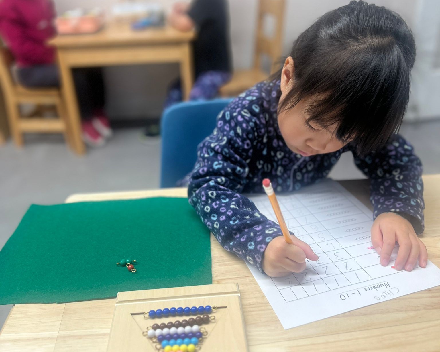 A mom and dad walking with their daughter along a treed path