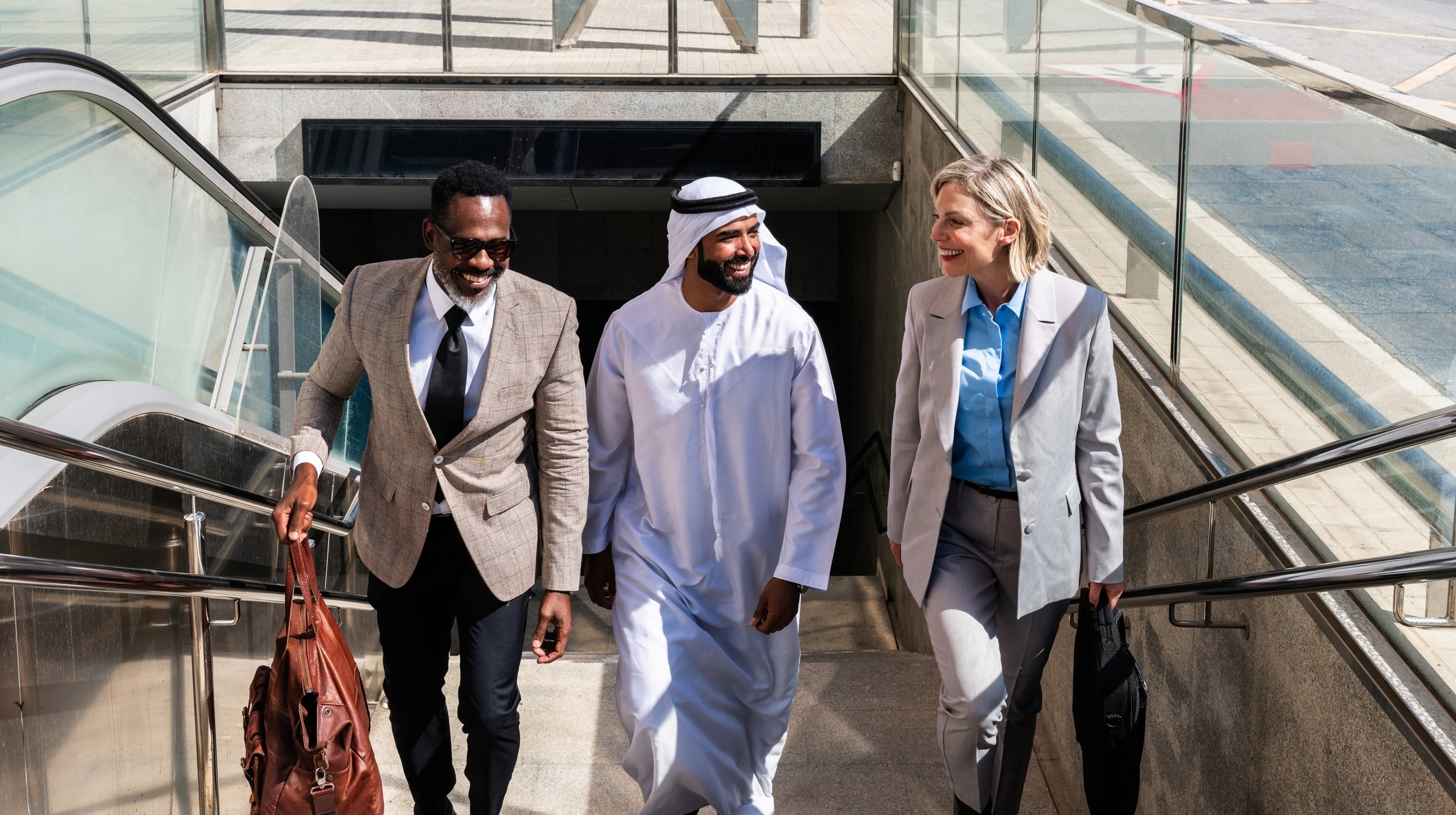 Business executives traveling in the Middle East, with Dubai and Riyadh skylines in the background, representing corporate mobility and immigration across GCC countries.