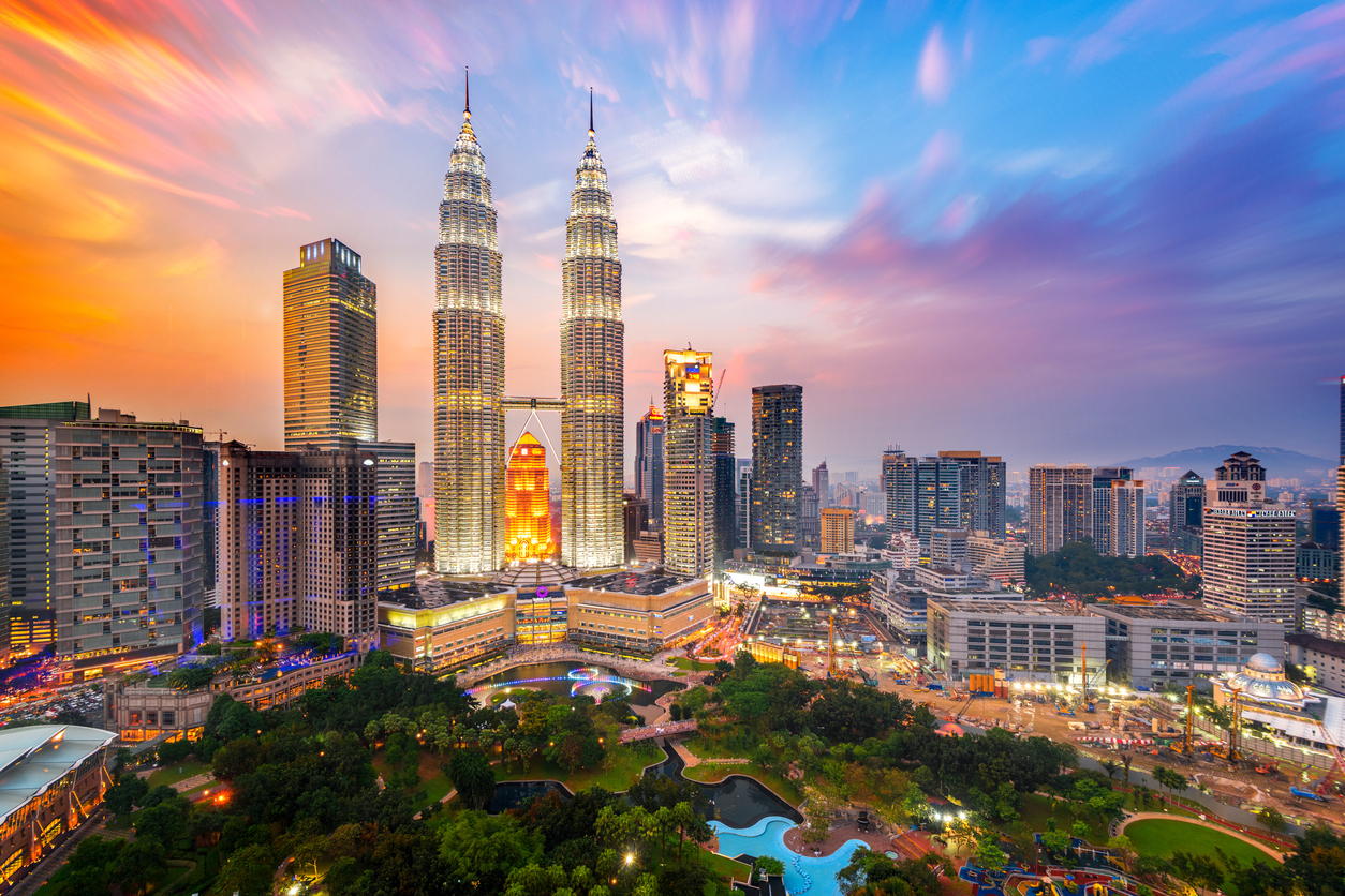 Expat professional looking out at the Kuala Lumpur skyline from a high-rise apartment, representing long-term residency and Malaysia MM2H programme.