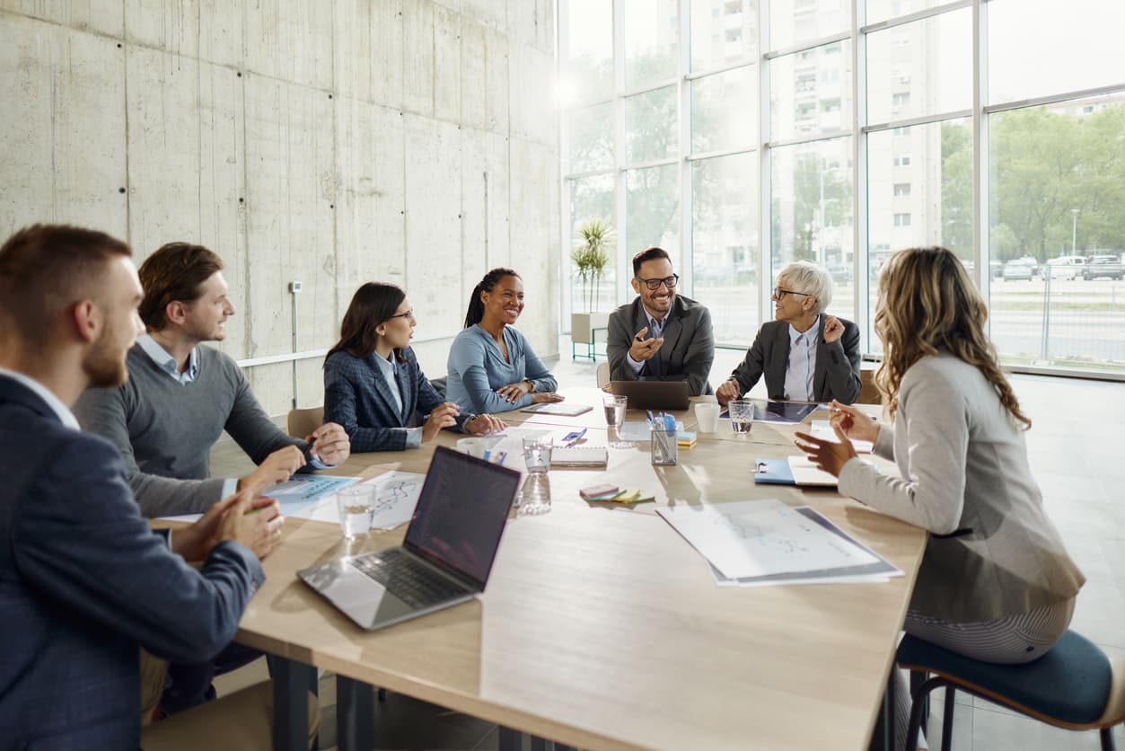 Senior executive team in boardroom discussing global talent and immigration strategy — Rahul Batra, CEO of Hudson McKenzie