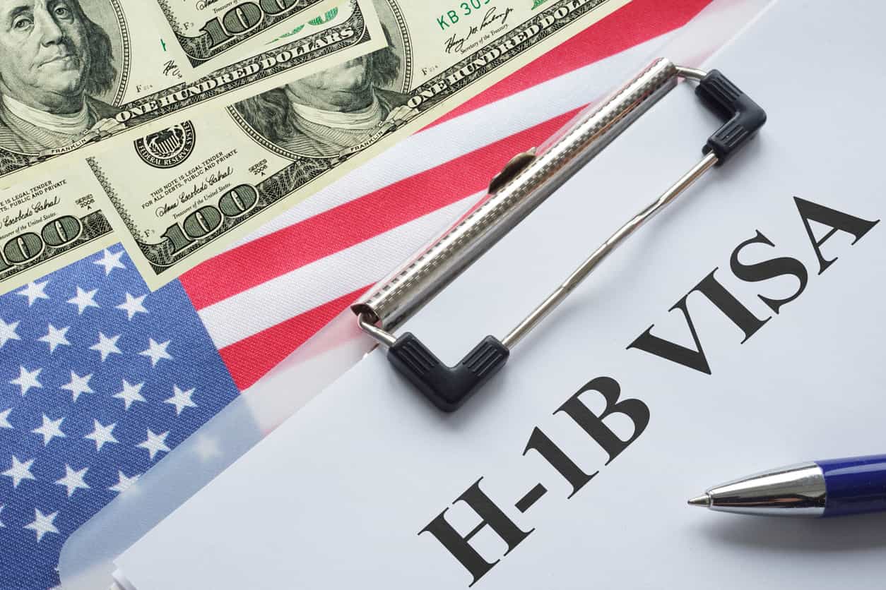 H-1B visa documents with U.S. flag and dollar notes representing the proposed $103,265 DHS fee for cap-subject petitions.