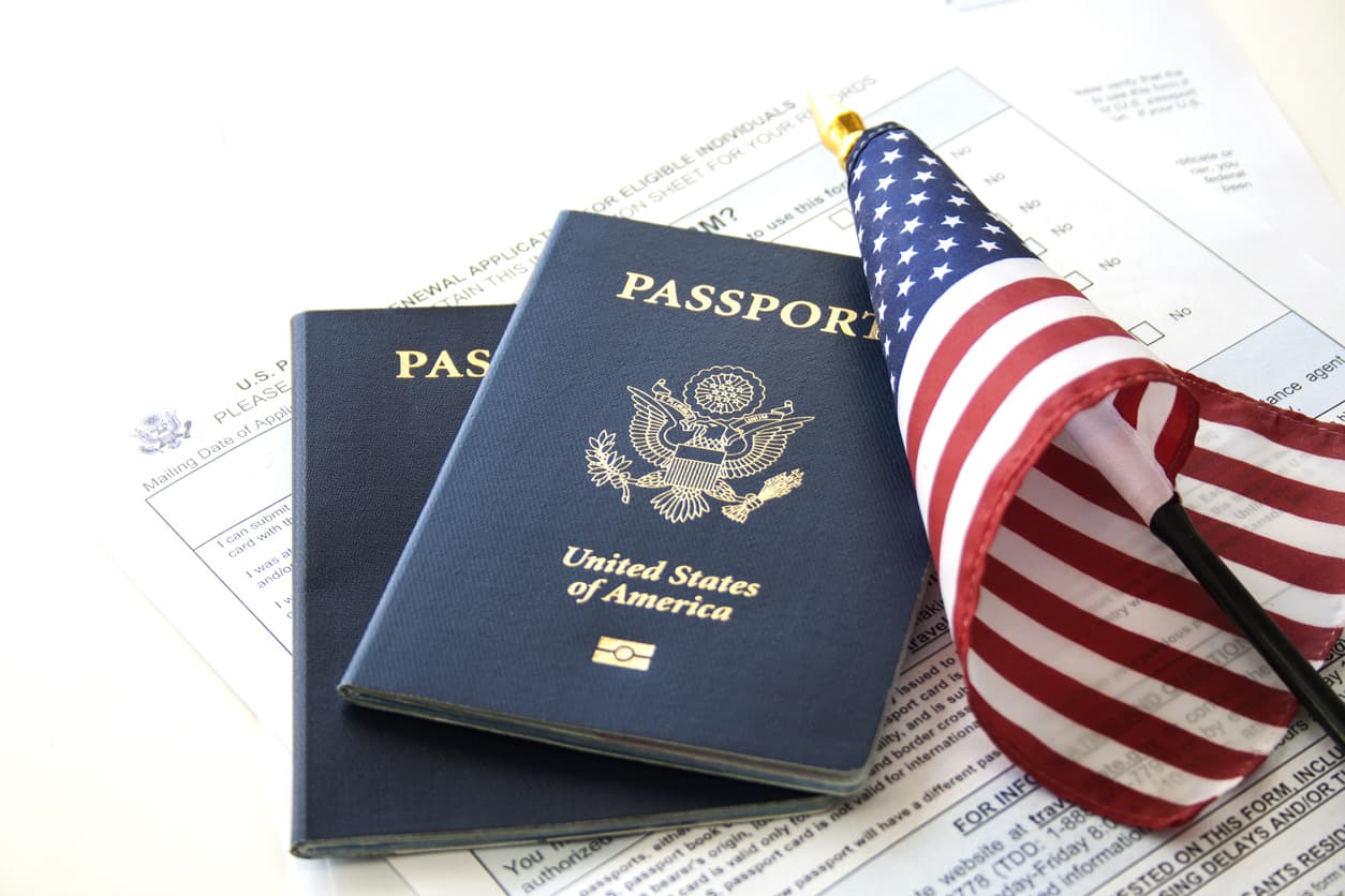 U.S. passports and American flag representing the end of the immigrant visa issuance pause