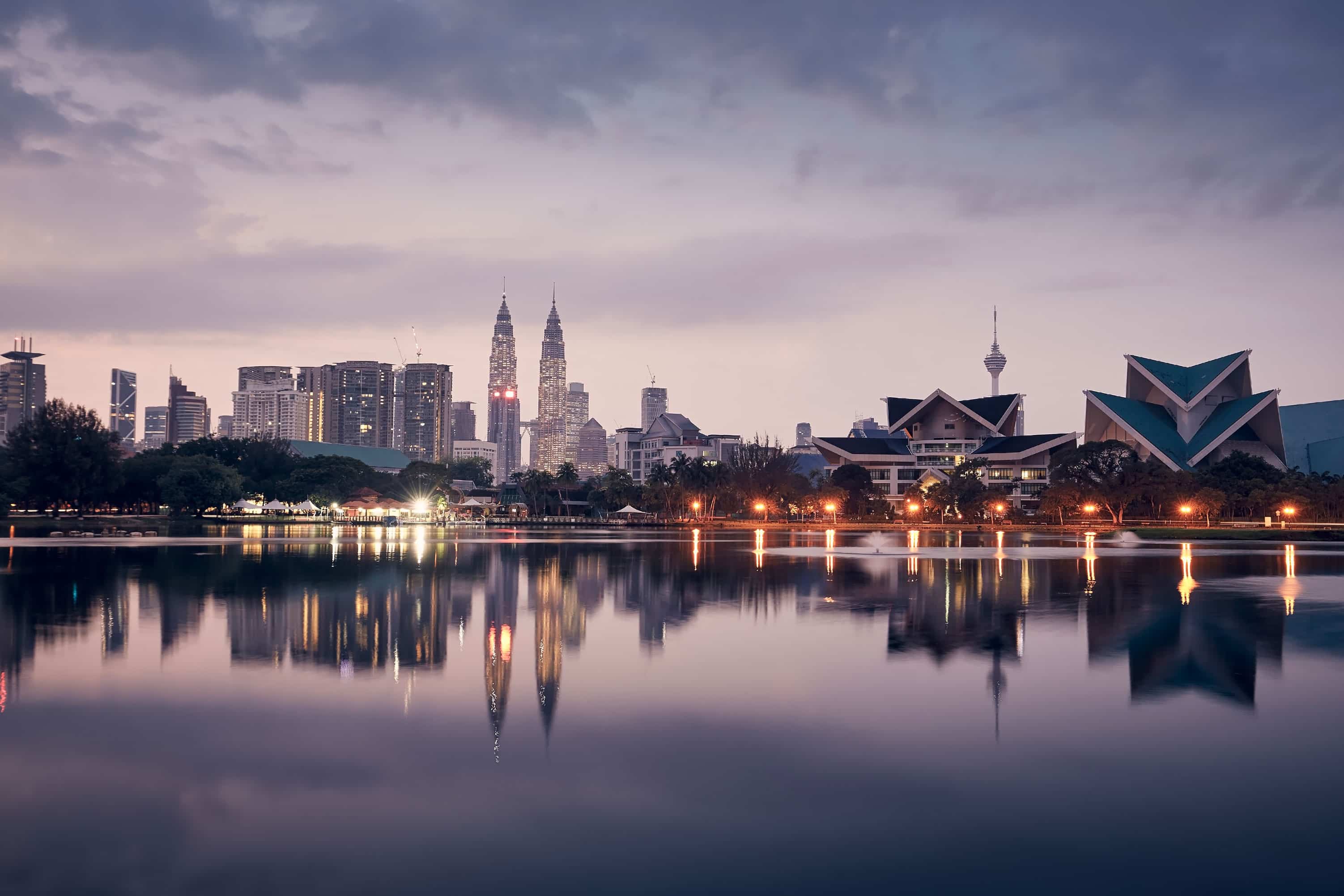 Kuala Lumpur skyline with the Petronas Twin Towers reflected in the lake at dusk