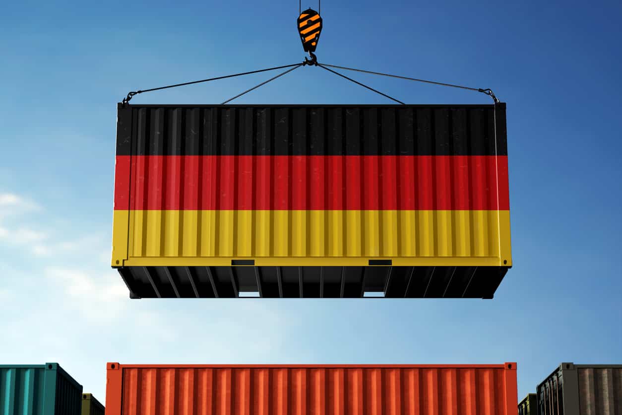 Shipping container in German flag colours being lifted at a logistics facility