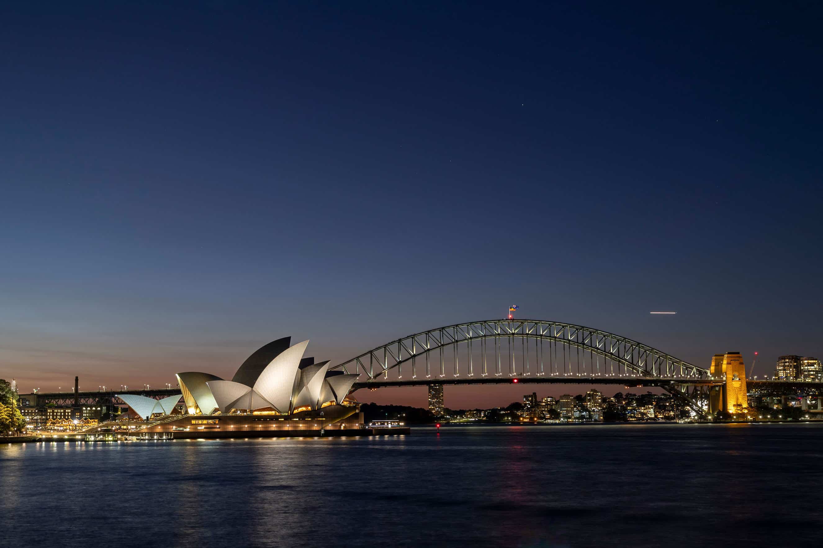 Sydney Opera House and Harbour Bridge illuminated at dusk in Australia