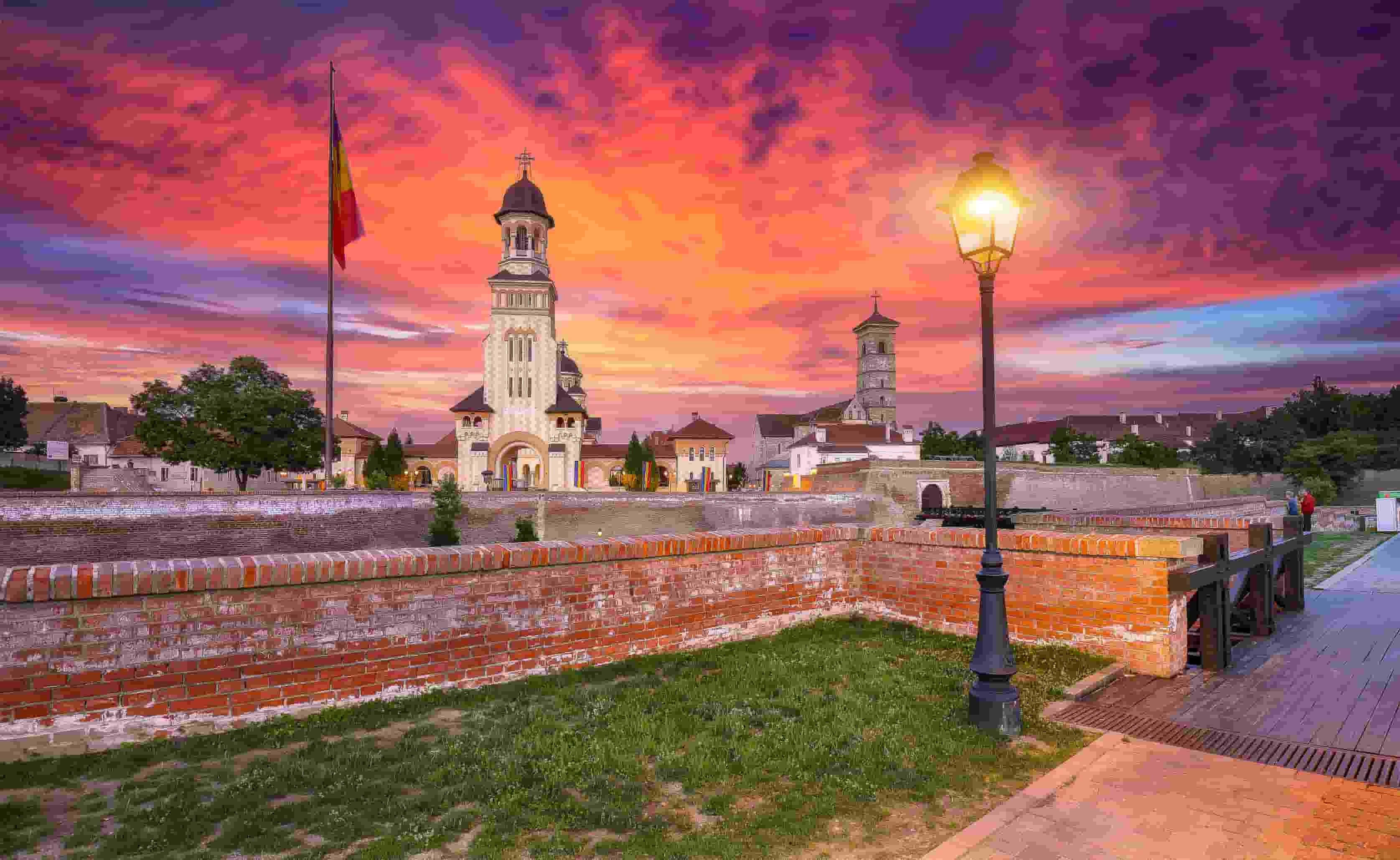 Romanian flag and historic cathedral at Alba Carolina Citadel in Alba Iulia, Romania