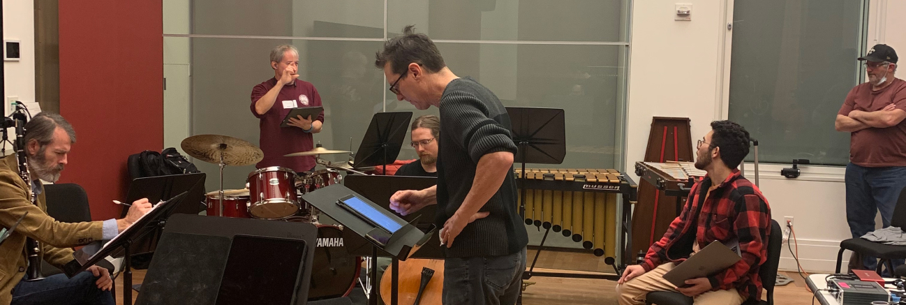 Education Director Kevin James conducts a student's piece of music with professional musicians