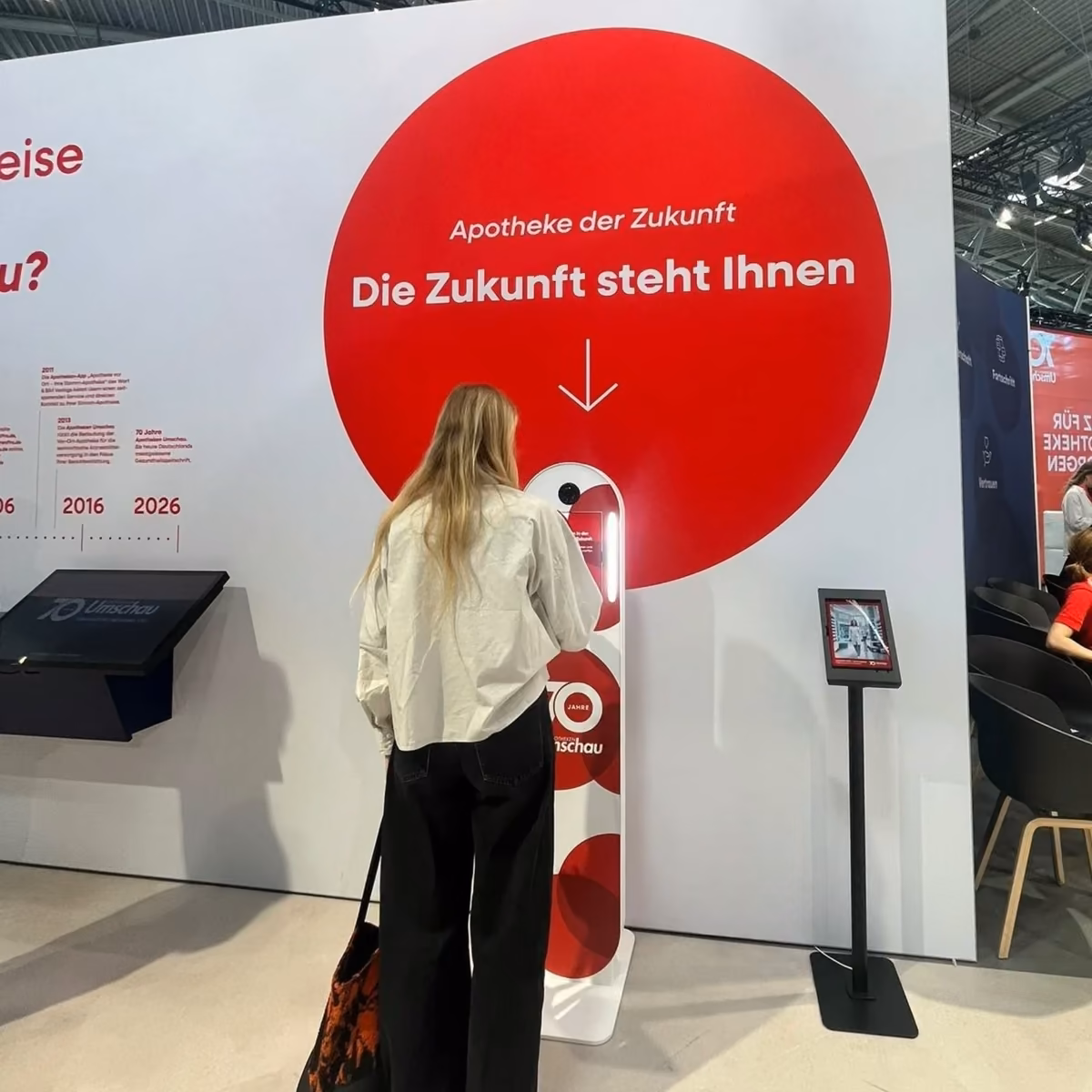 Bild einer Frau, die ein Foto an der Fotobox aufnimmt am Messestand.