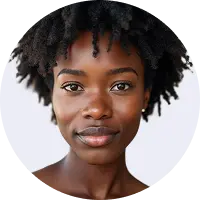 Close-up portrait of a young woman with natural curly hair, clear skin, and a confident expression against a white background.