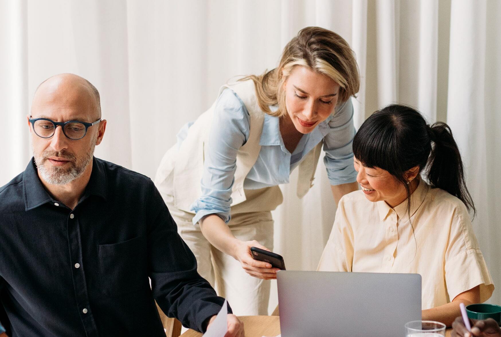 Drei Kollegen arbeiten gemeinsam am Laptop im Meeting