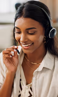 Smiling woman wearing headset and speaking while working remotely.