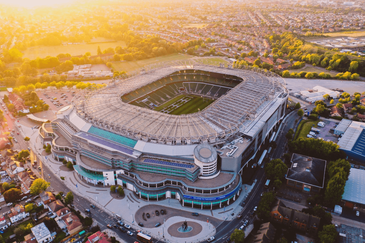 Aerial view of Twickenham Stadium at sunset with surrounding residential and industrial areas.
