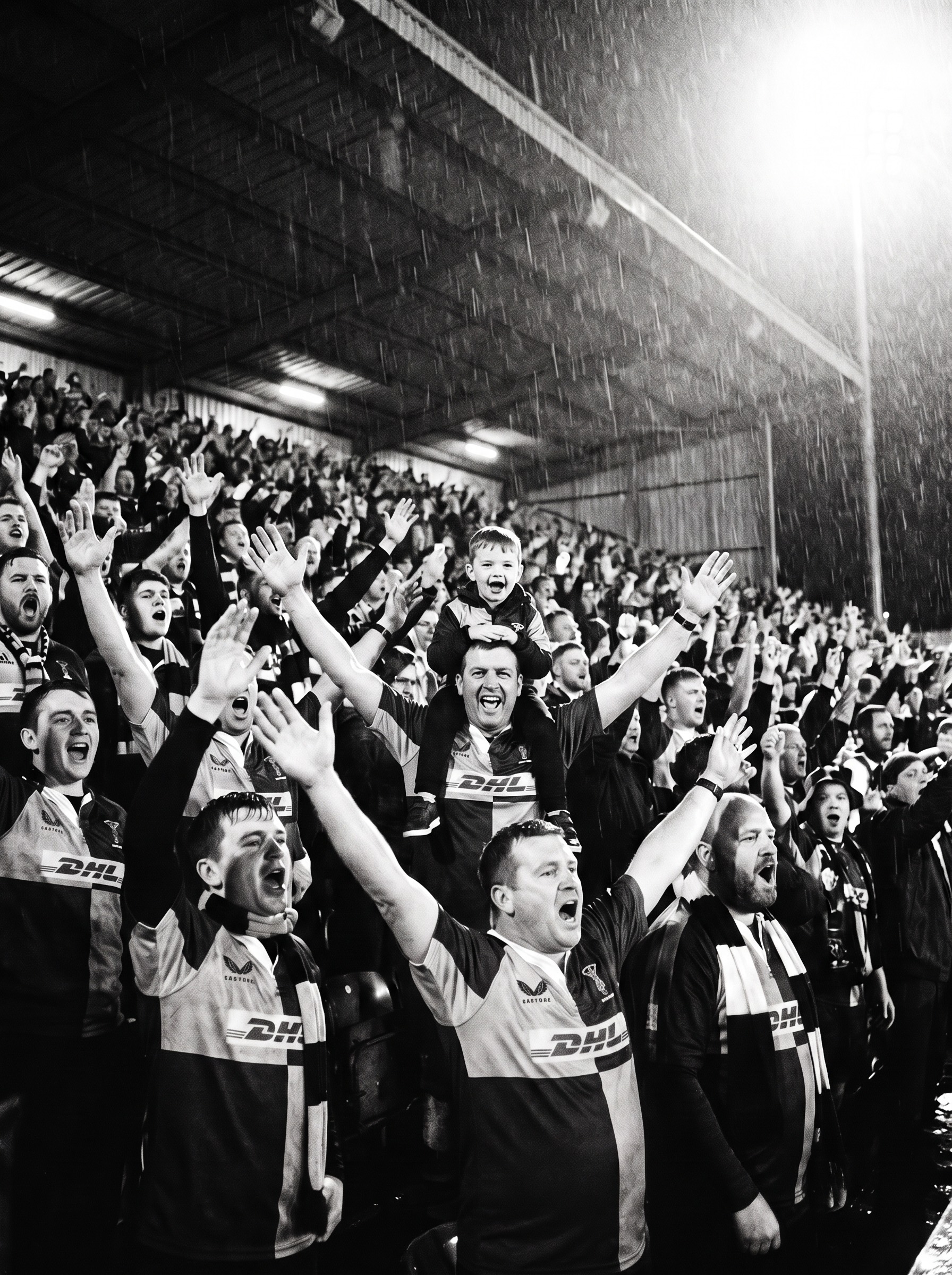 Harlequins supporters singing in a packed stand under floodlights