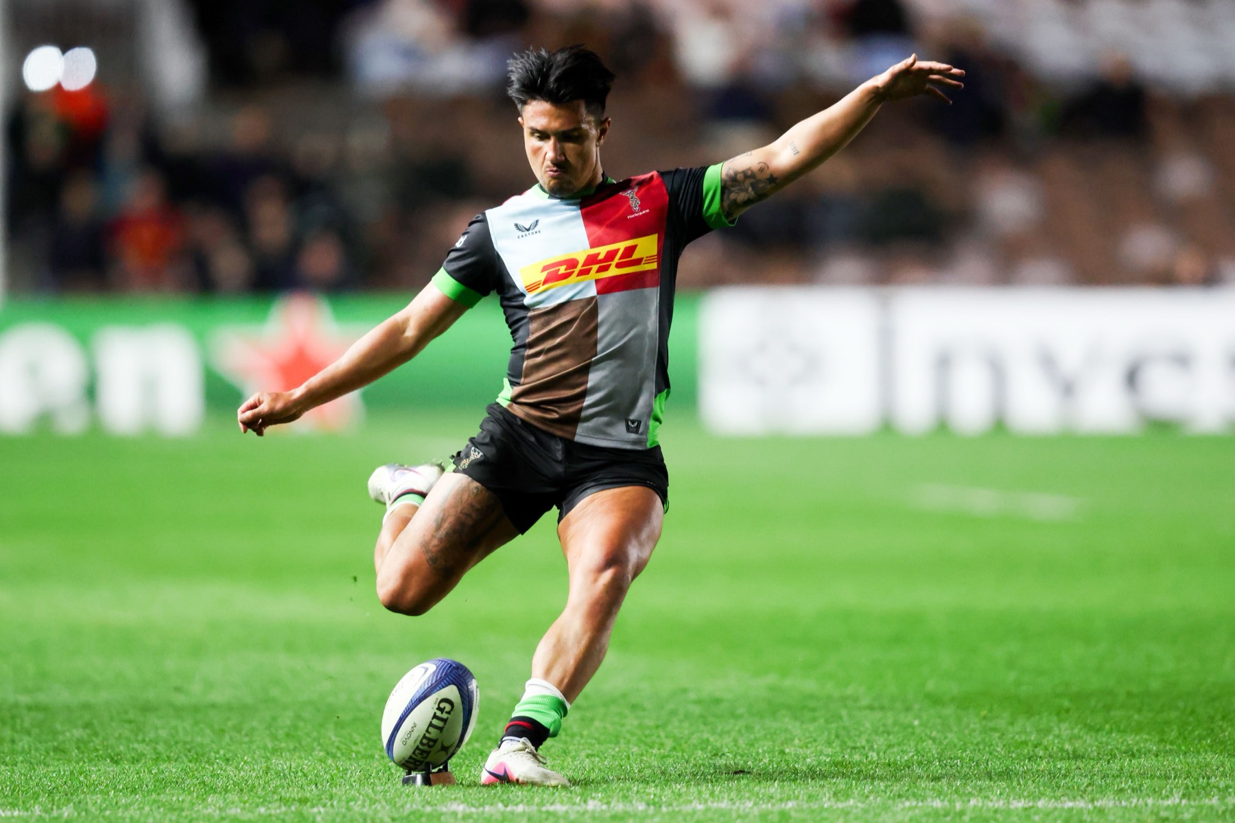 A Harlequins goal kicker strikes the ball off the tee