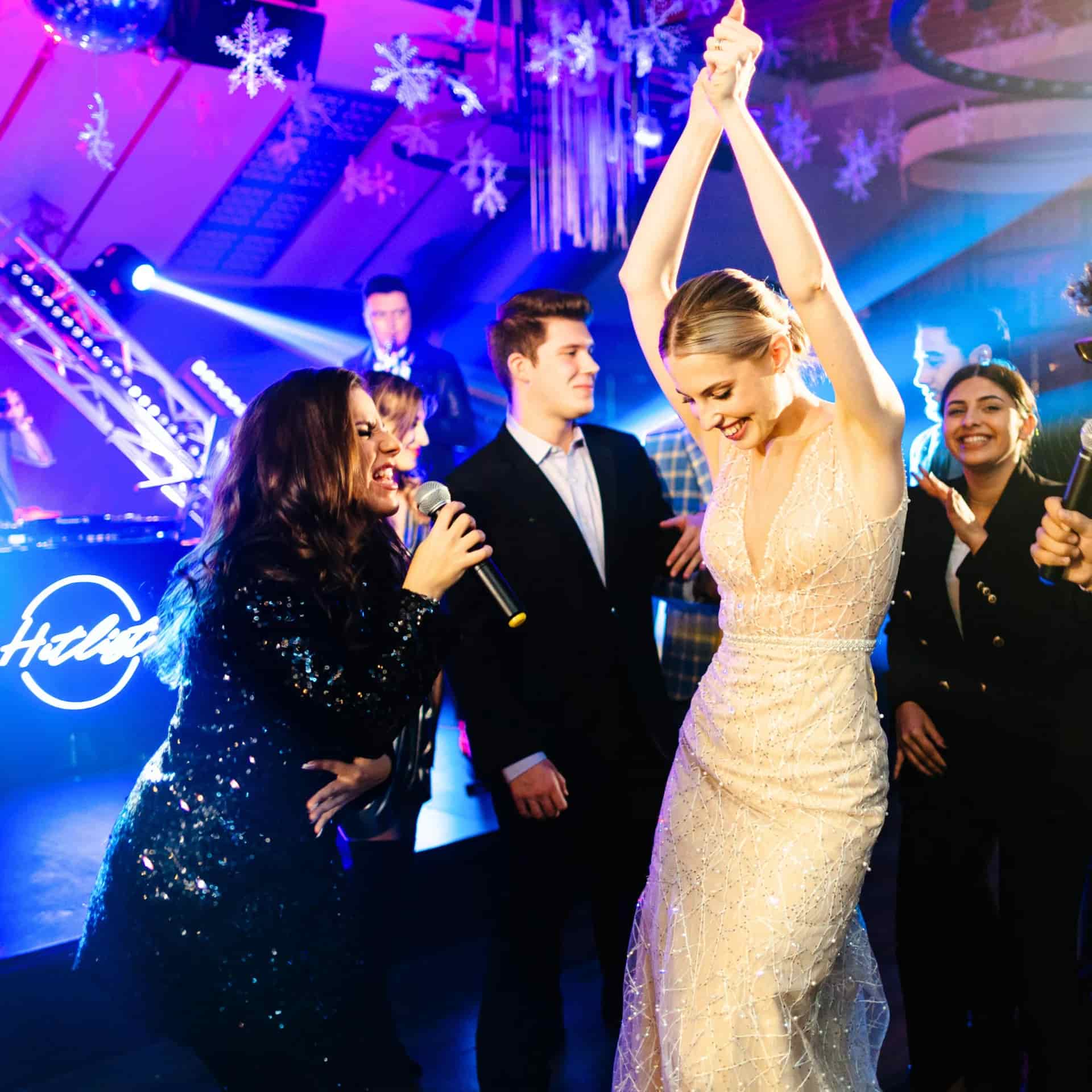 Public dansând pe ring sub lumini albastre și roz