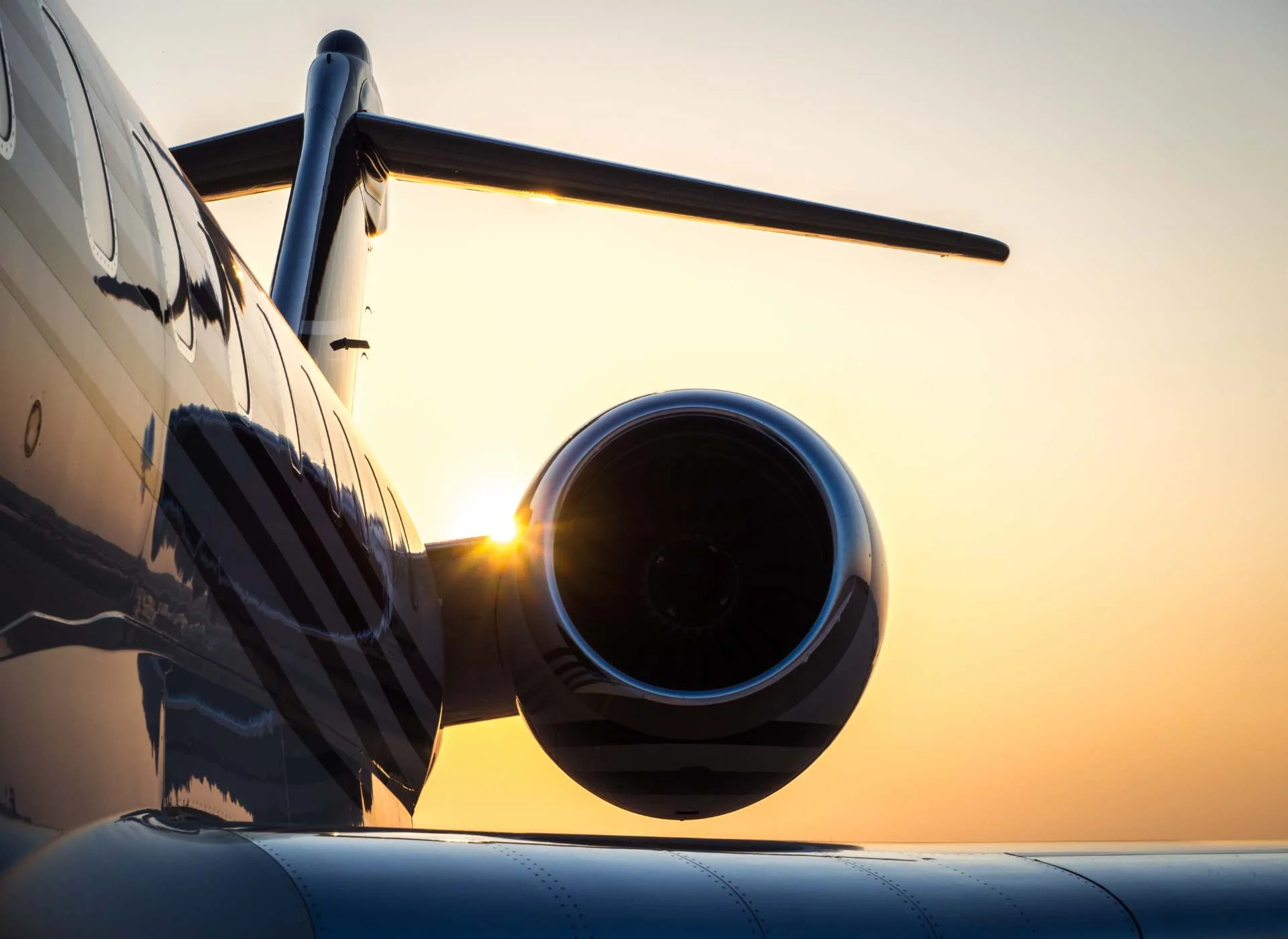 Bombardier Global 6000 rear engine and tail detail, ultra-long-range private jet at sunset.