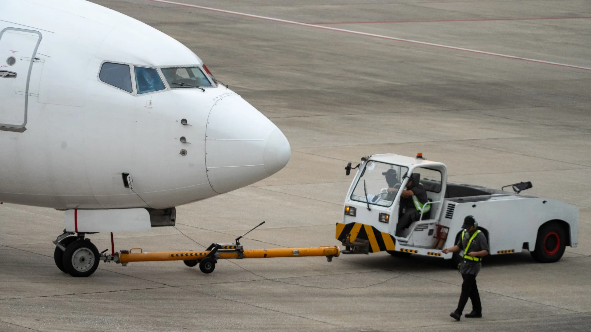Ground crew agent performing a pushback on an aircraft prior to departure