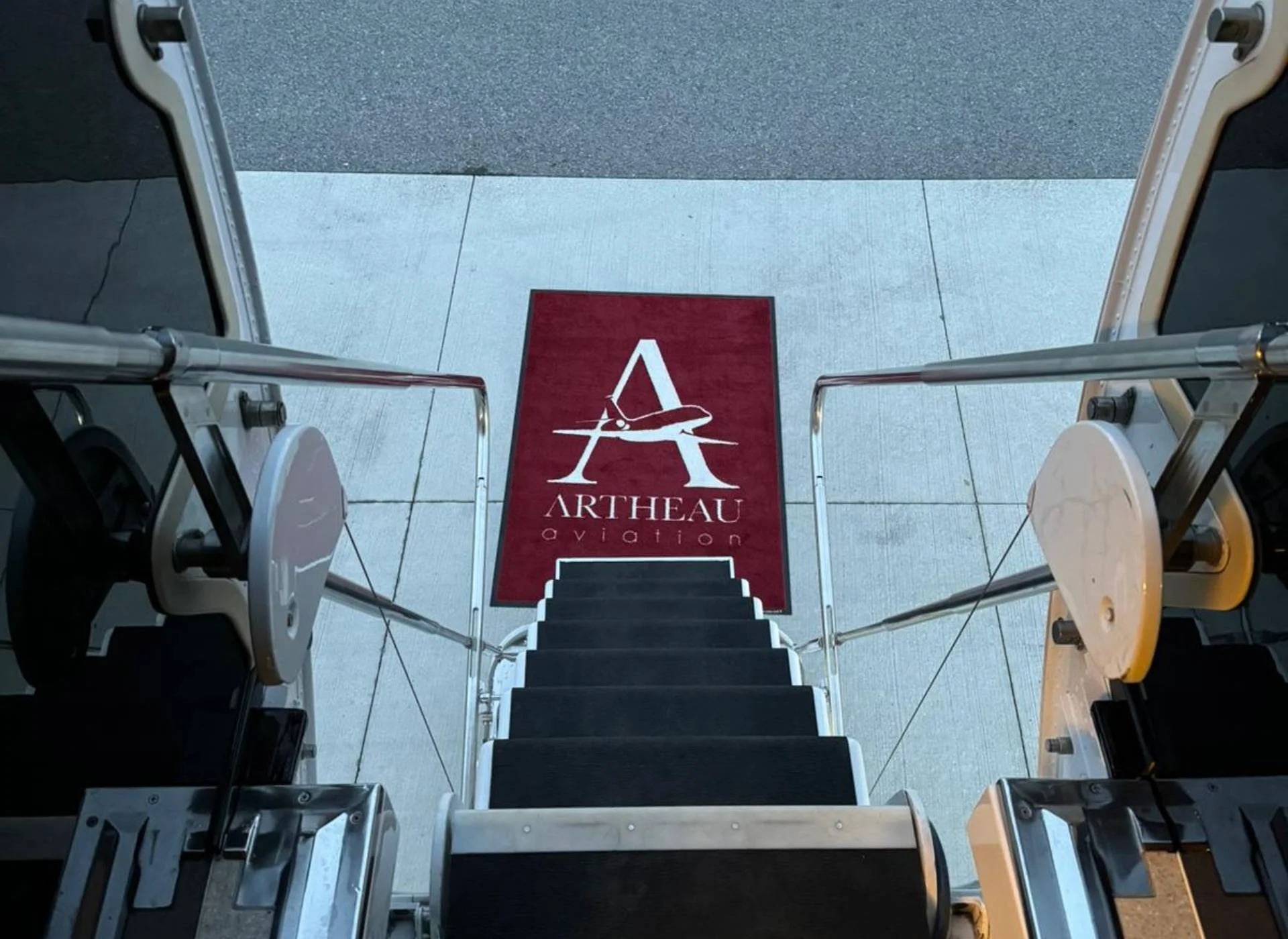 Escalier d’accès à un jet privé avec tapis Artheau Aviation pour embarquement VIP