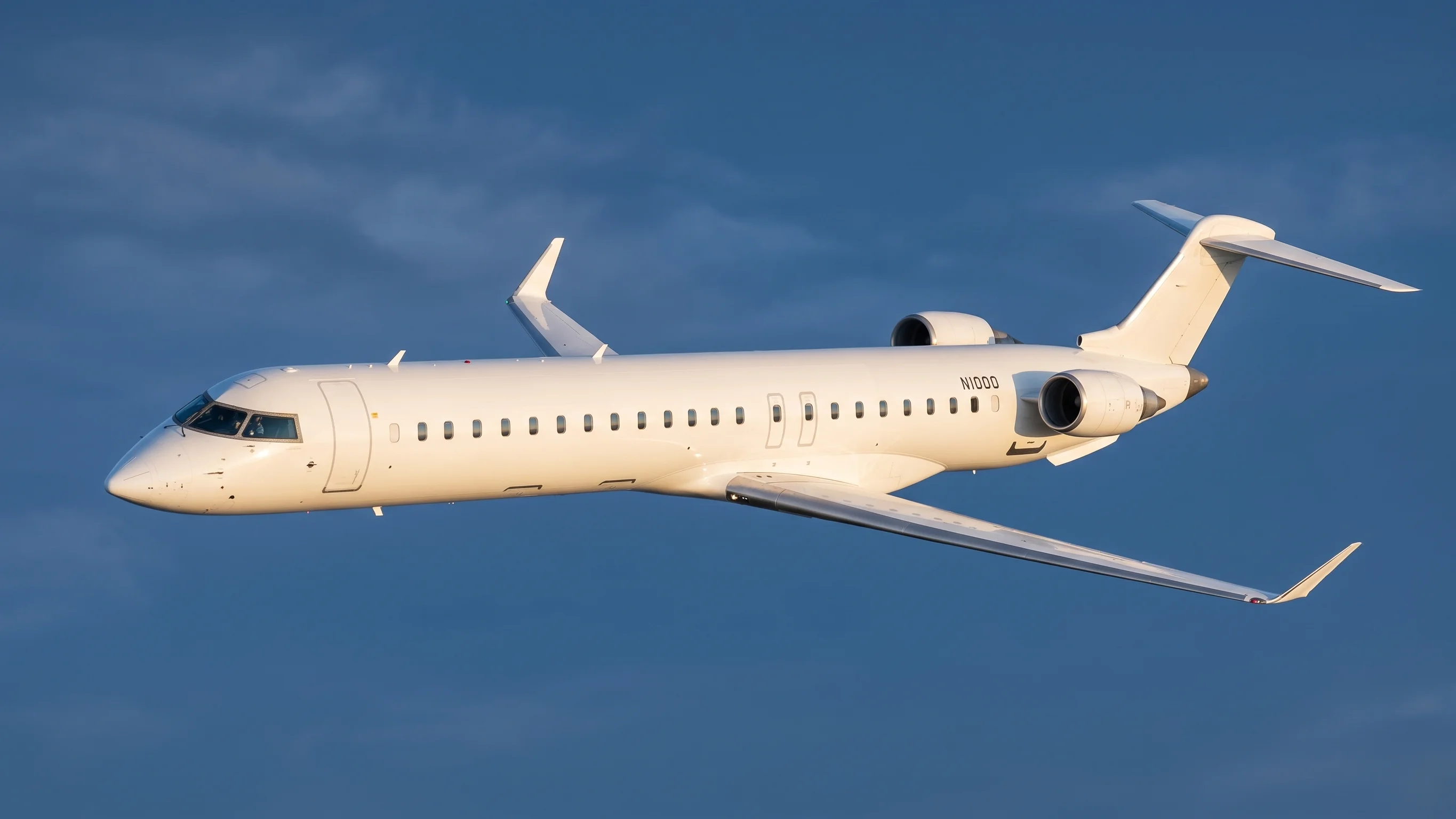 CRJ1000 aircraft climbing after takeoff, silhouetted against a blue sky