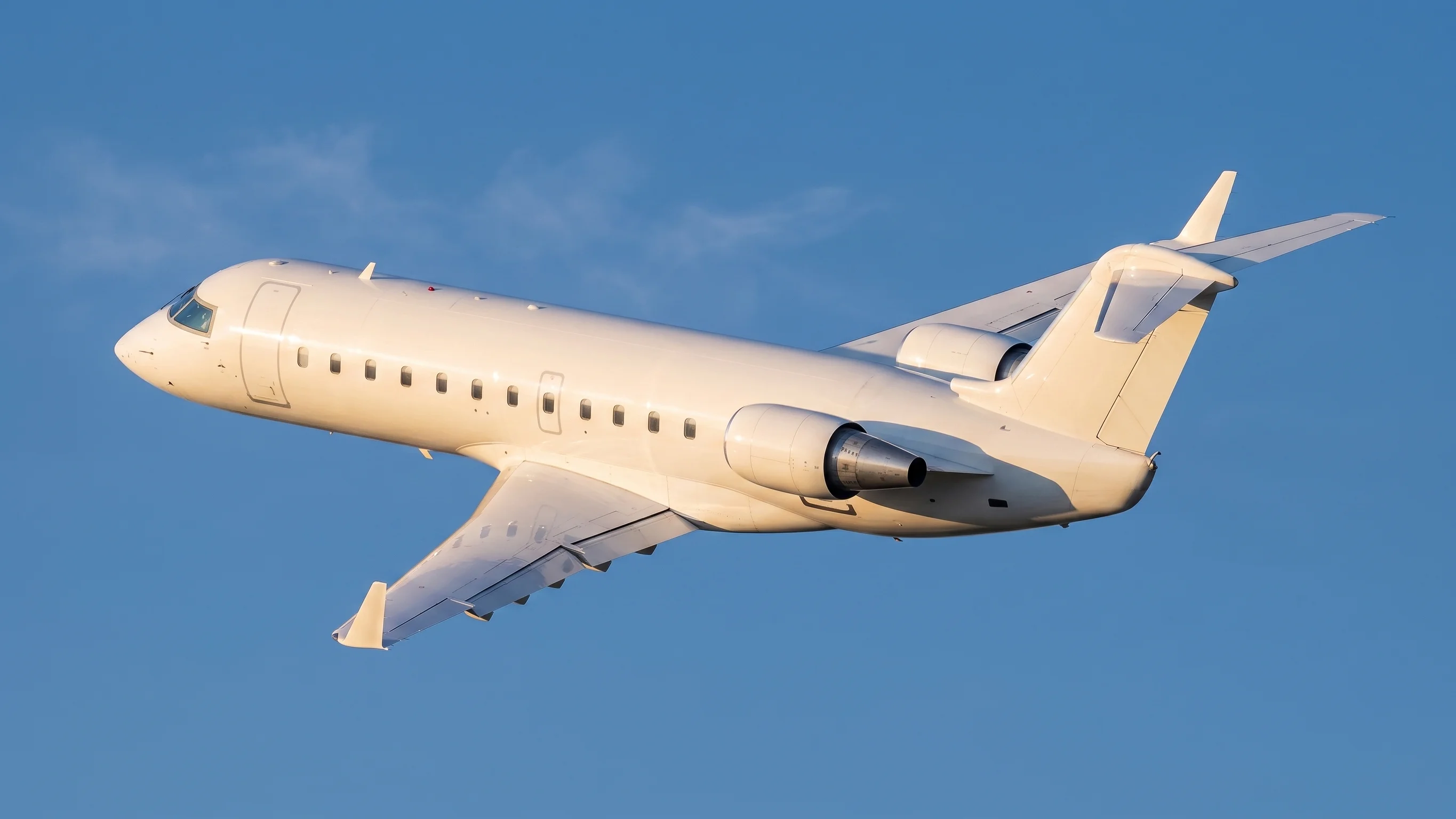 ide view of a CRJ200 aircraft climbing against a clear blue sky
