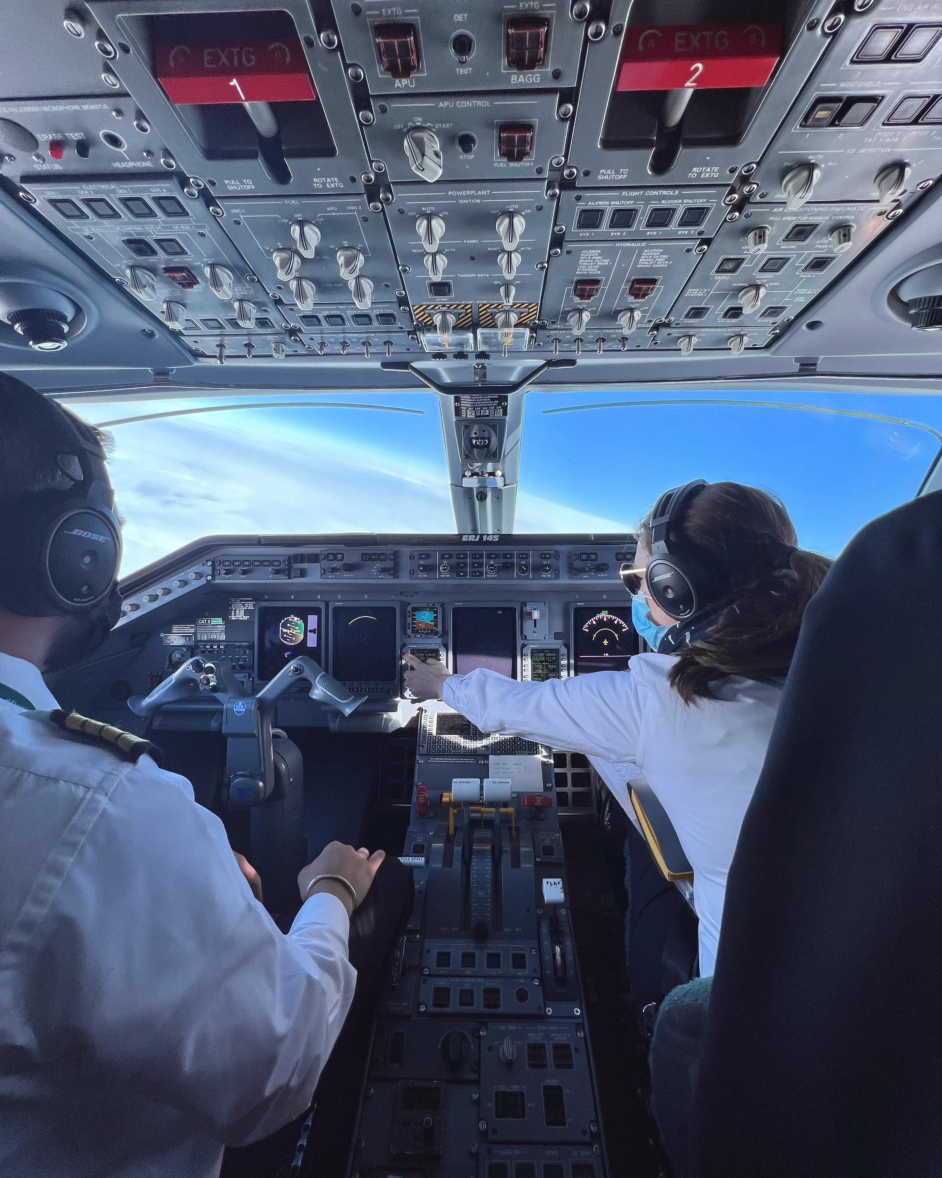 Cockpit view of an ERJ145 aircraft in flight with pilots at the controls