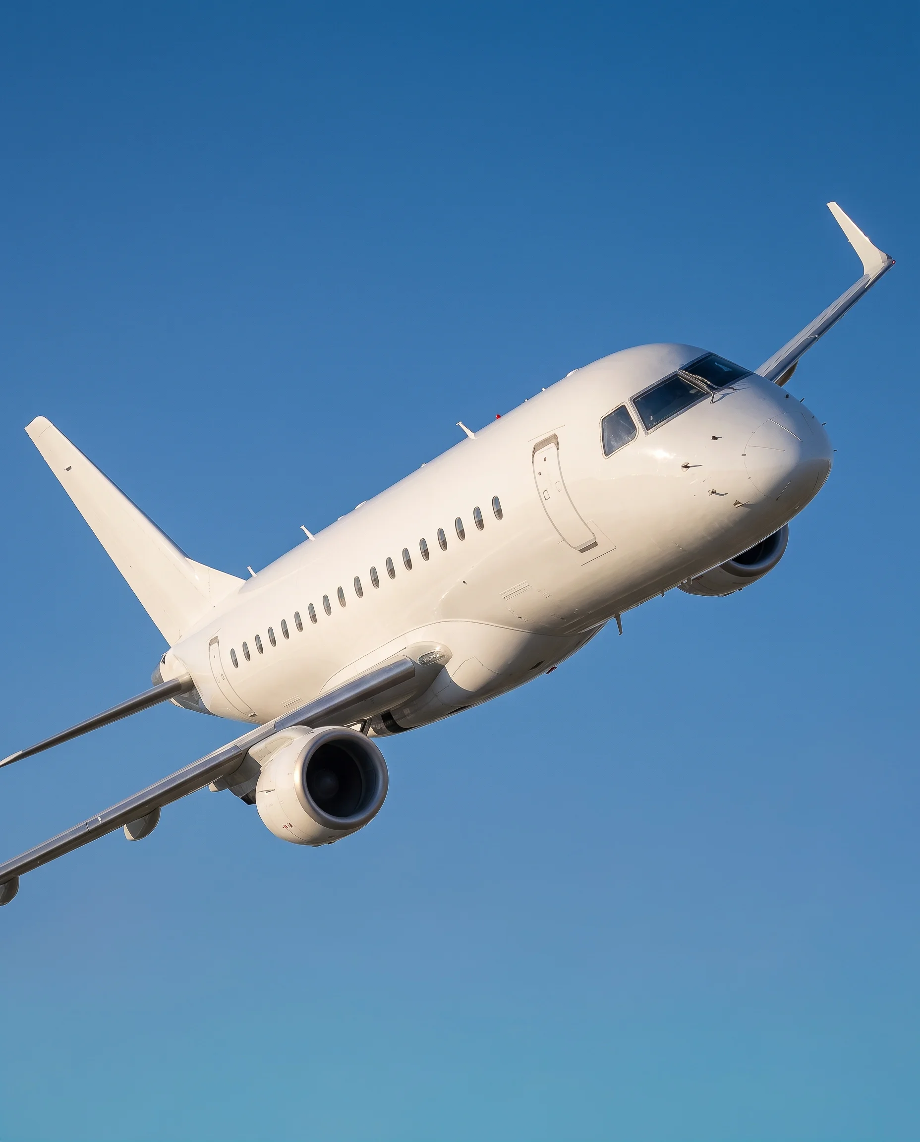 	Side view of an Embraer ERJ170 aircraft in flight against a clear blue sky
