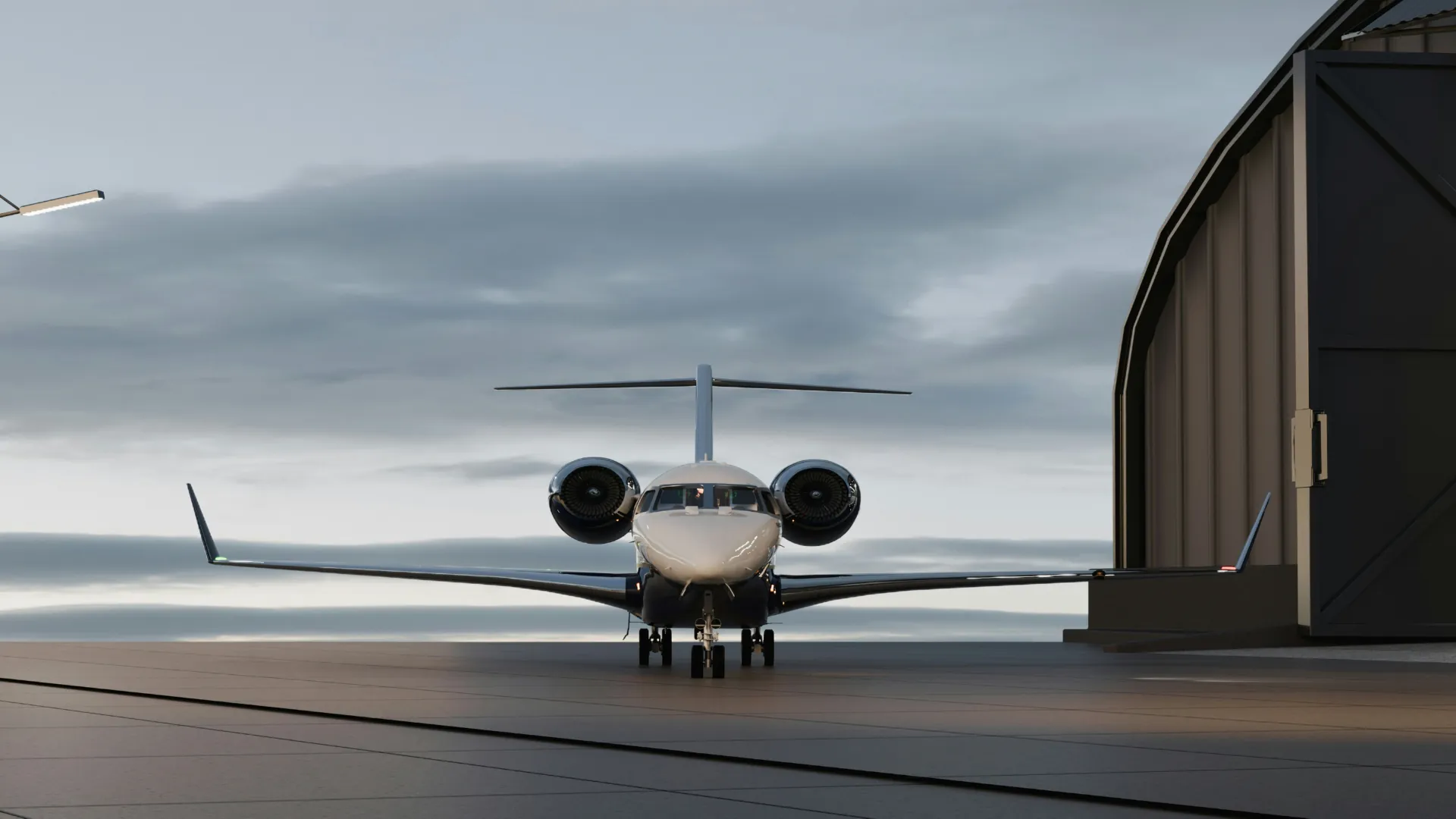 Jet d'affaires vu de face, stationné devant un hangar sous un ciel nuageux au lever du jour