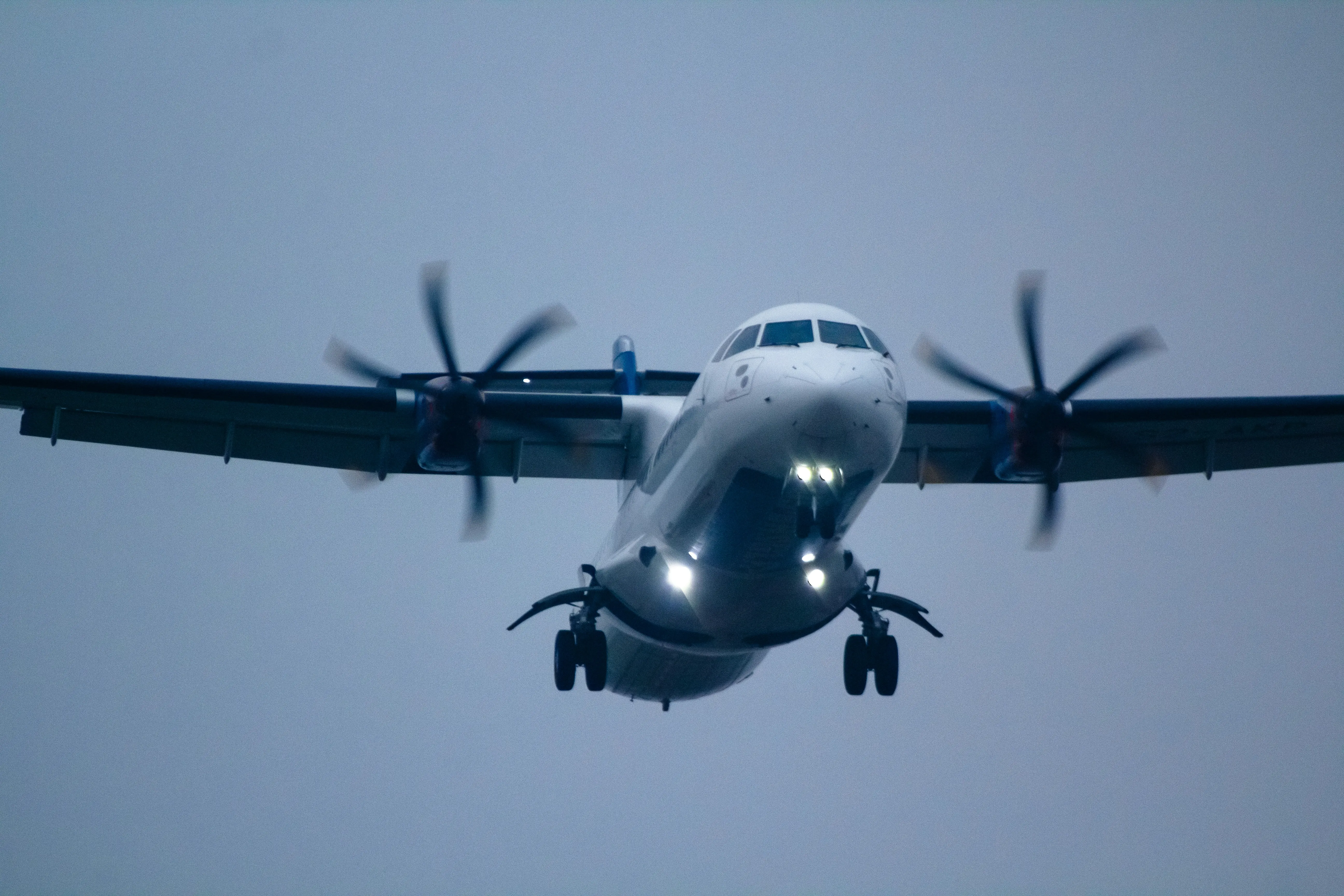 Front view of an ATR 72 turboprop aircraft with landing gear extended