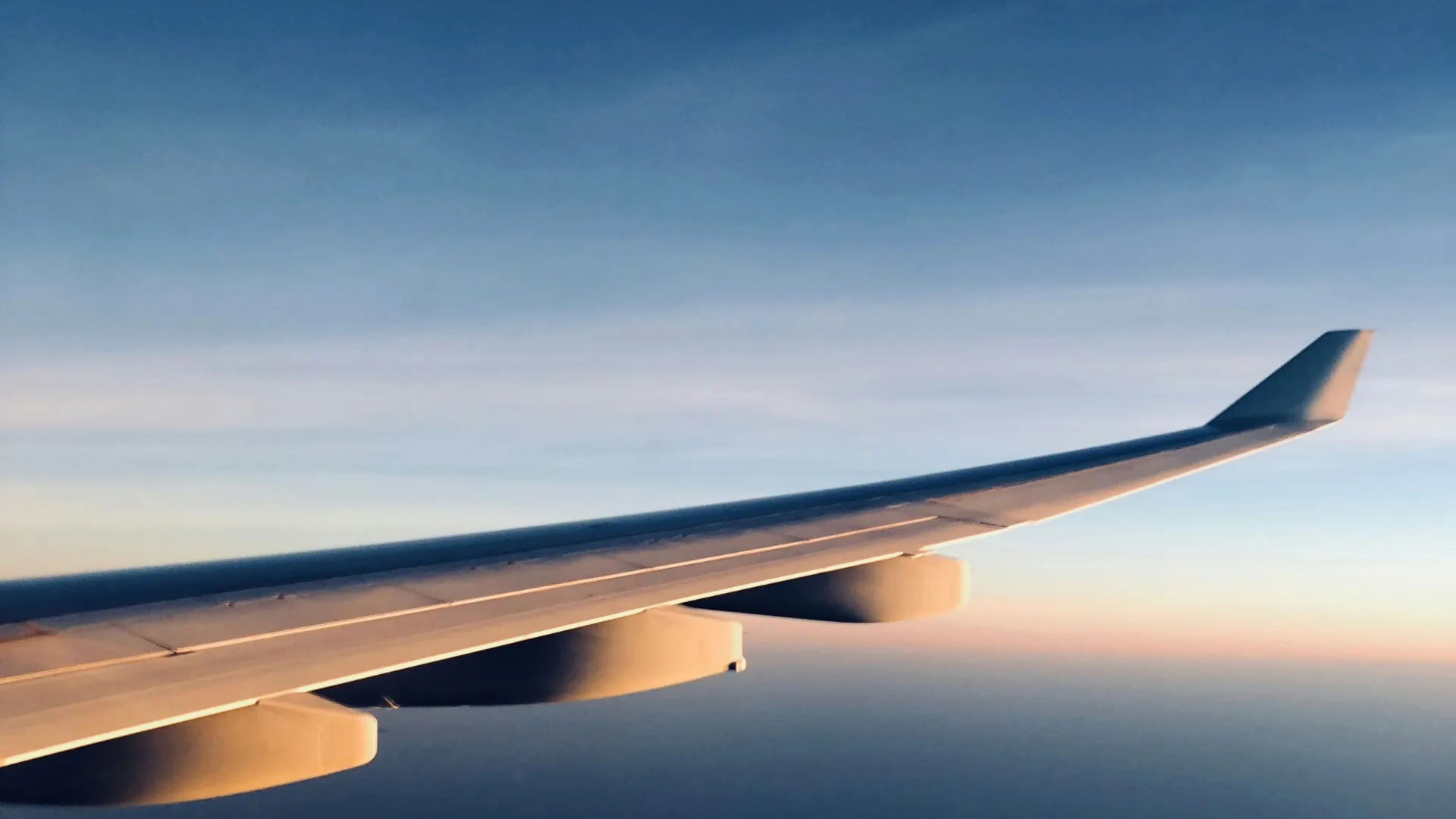 Aircraft wing in flight at sunrise