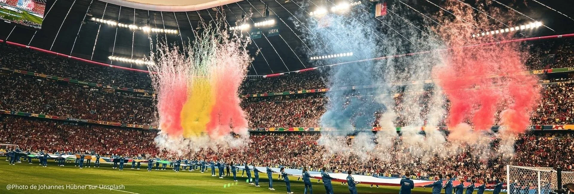 Football stadium crowd during a pre-match ceremony with coloured smoke
